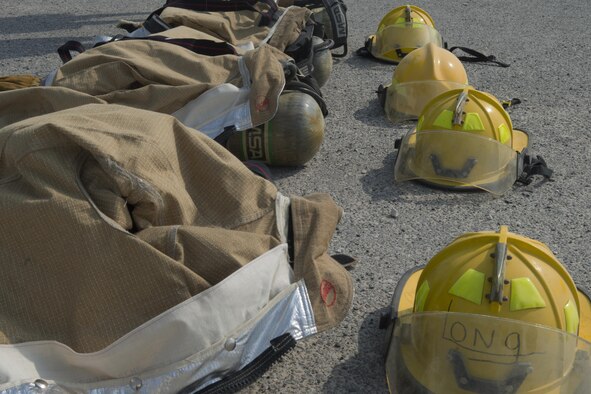 Protective equipment used by firefighters lines the ground at Al Udeid Air Base, Qatar Oct. 10, 2015. The PPE was used by nearly 100 people who took part in the Fire Muster, a firefighter skills competition designed to provide people with an idea of what firefighters have to deal with on a regular basis. The competition featured numerous challenges for would-be firefighters, including a skills obstacle course and water jousting. (U.S. Air Force Photo/Tech. Sgt. James Hodgman)