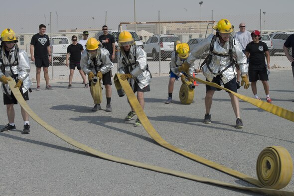 Service members deployed to Al Udeid Air Base, Qatar participated in the Fire Muster, a firefighter skills competition on Oct. 10, 2015. The competition featured numerous challenges for would-be fire fighters, including a skills obstacle course and water jousting. Nearly 100 people took part in the event, which organizers said was designed to provide people with an idea of what firefighters have to deal with on a regular basis. (U.S. Air Force Photo/Tech. Sgt. James Hodgman)