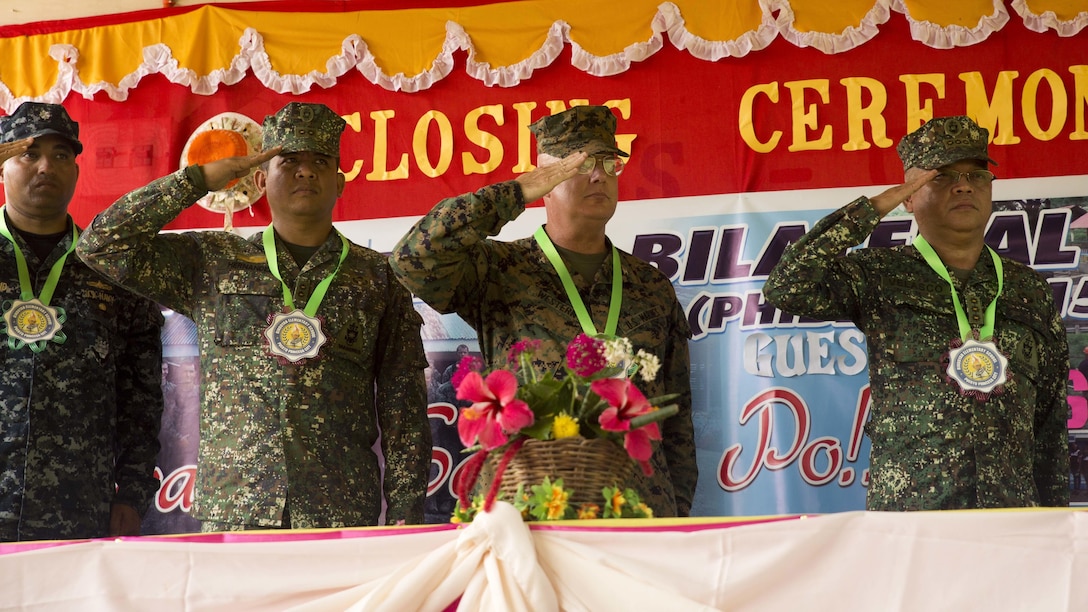 U.S. and Philippine service members salute  at the ribbon cutting ceremony Oct. 8, in Puerta Princesa, during Amphibious Landing Exercise 2015. PHIBLEX is an annual, bilateral training exercise conducted by members of the Armed Forces of the Philippines alongside U.S. Marine and Navy Forces. It focuses on strengthening the partnership and relationships between the two nations across a range of military operations, including disaster relief and complex expeditionary operations. The ribbon cutting ceremony signified the end of the Humanitarian Civic Assistance projects at the Concepcion and Binduyan Elementary schools. (U.S. Marine photo by Cpl. Robert Williams Jr./Released)