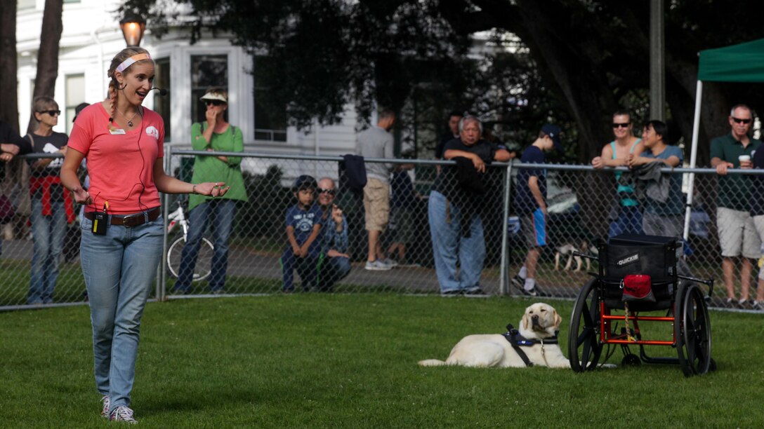 Oz Robinson, an apprentice instructor with canine companions, explains the different capabilities of their trained service dogs during the Bark at the Park event Oct. 10, as part of San Francisco Fleet Week 2015. SFFW 15’ is a week-long event that blends a unique training and education program, bringing together key civilian emergency responders and Naval crisis-response forces to exchange best practices on humanitarian assistance disaster relief with particular emphasis on defense support to civil authorities.