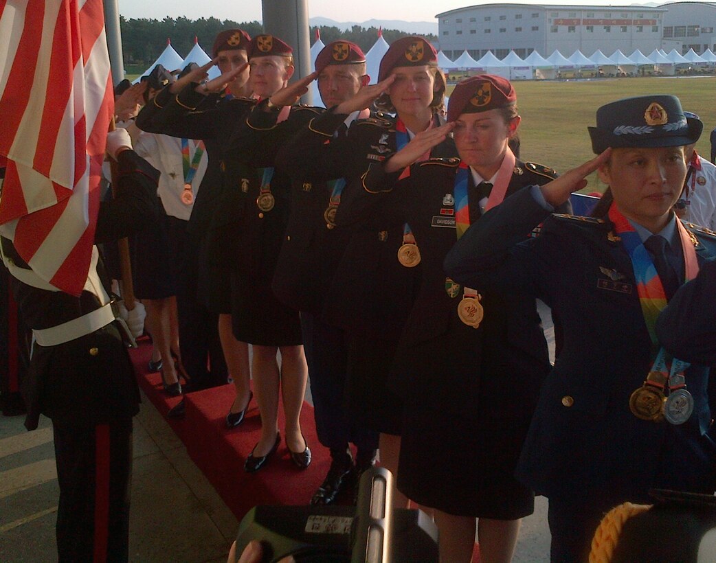 Team USA members salute the colors after being awarded gold for formation skydiving at the CISM World Games in South Korea, Oct. 8, 2015. From front to back are: Sgts. 1st Class Jennifer Davidson, Laura Davis, Scott Janice, Angela Nichols and Dannielle Woosley.