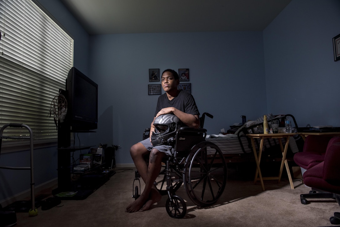 Spc. Nicolas Laboy, U.S. Army Reserve information technology specialist for the 416th Theater Engineer Command, poses in his wheelchair at his house in Bolingbrook, Ill., Sept. 29, holding his motorcycle helmet that saved his life during an accident three months earlier. Laboy is expected to walk again after three more months of physical therapy. During his accident, Laboy broke his right leg, received a third-degree burn in his left thigh, severed his kidney and liver, fractured his lower spine and his right shoulder, and suffered internal bleeding in his brain. (U.S. Army photo by Master Sgt. Michel Sauret)