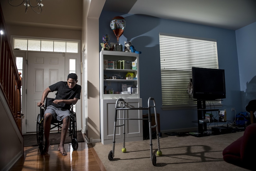 Spc. Nicolas Laboy, U.S. Army Reserve information technology specialist for the 416th Theater Engineer Command, poses in his wheelchair three months after a motorcycle accident at his house in Bolingbrook, Ill., Sept. 29, next to the downstairs living room that has been turned into his bedroom. Laboy is expected to walk again after three more months of physical therapy. During his accident, Laboy broke his right leg, received a third-degree burn in his left thigh, severed his kidney and liver, fractured his lower spine and his right shoulder, and suffered internal bleeding in his brain. (U.S. Army photo by Master Sgt. Michel Sauret)