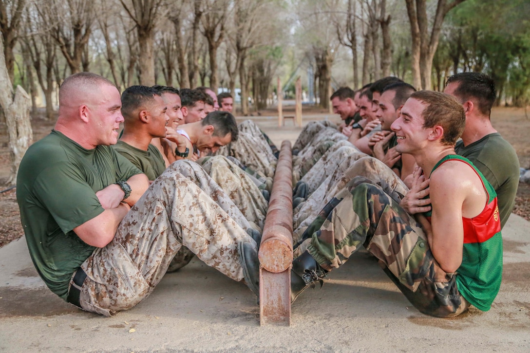 U.S. Marines with the 15th Marine Expeditionary Unit and the French 5th Overseas Combined Arms Regiment (RIAOM) perform crunches as part of indoctrination prior to participating in a desert survival course. Elements of the 15th MEU are training with the 5th RIAOM in Djibouti in order to improve interoperability between the MEU and the French military. 