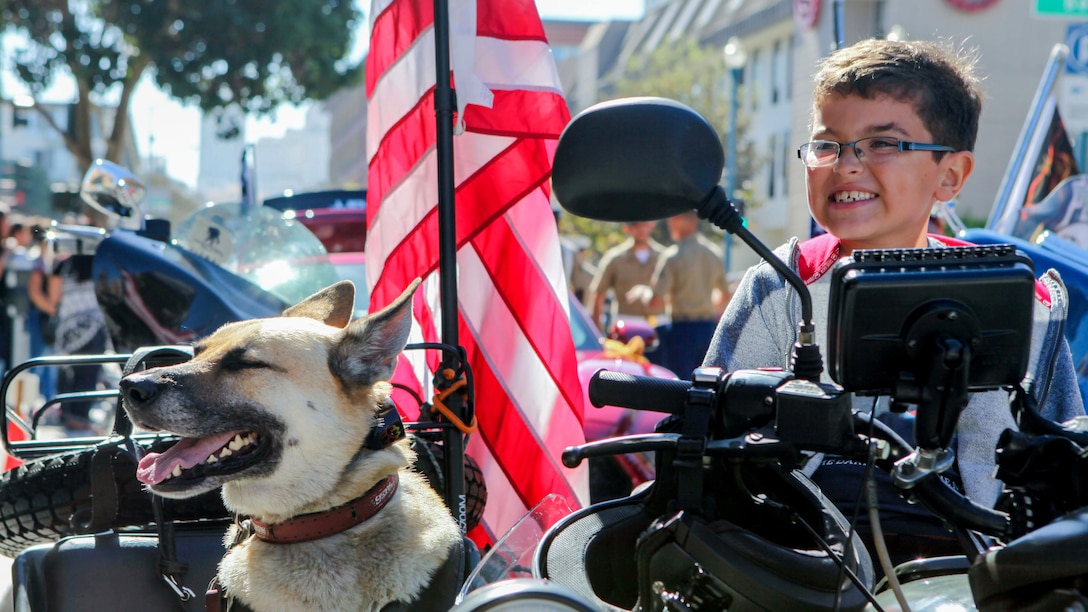 A young boy sits on a motorcycle with a dog while waiting for the Italian heritage parade to start on Oct. 11., as part of San Francisco Fleet Week 2015. SFFW '15 is a week-long event that blends a unique training and education program, bringing together key civilian emergency responders and Naval crisis-response forces to exchange best practices on humanitarian assistance disaster relief with particular emphasis on defense support to civil authorities.