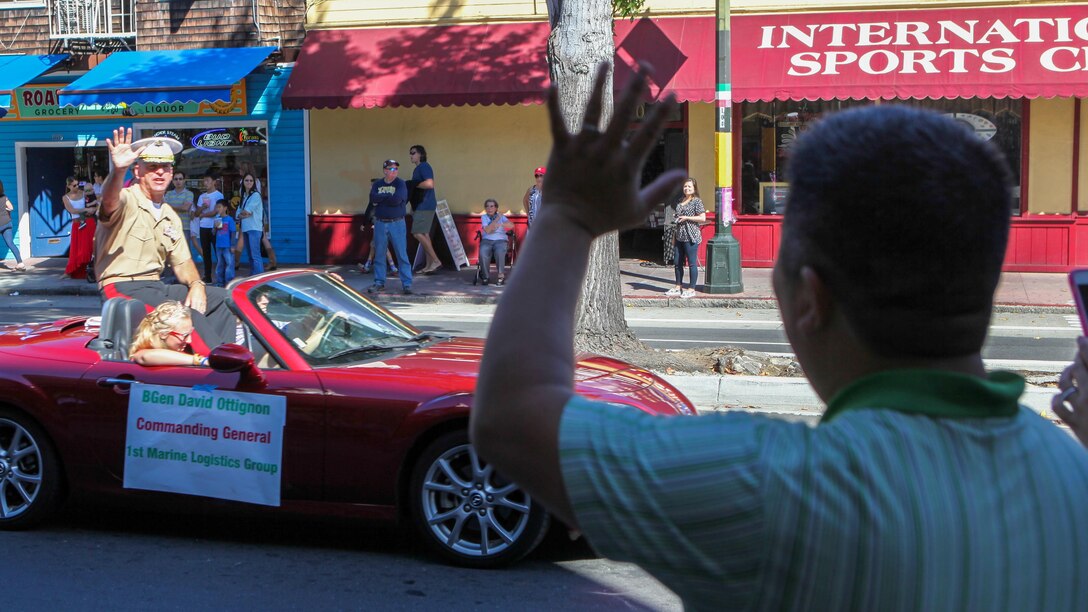 Brig. Gen. David Ottignon, the commanding general of 1st Marine Logistics Group, waves to San Francisco residents during the Italian Heritage parade Oct. 11, as part of San Francisco Fleet Week 2015. SFFW '15 is a week-long event that blends a unique training and education program, bringing together key civilian emergency responders and Naval crisis-response forces to exchange best practices on humanitarian assistance disaster relief with particular emphasis on defense support to civil authorities.