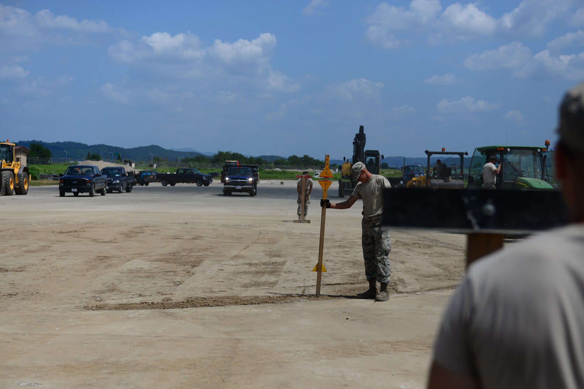 Airmen from the 51st Civil Engineer Squadron pavement and constructions equipment shop, use a combination of heavy equipment and hand tools, to repair a crater during airfield damage repair training at Osan Air Base, Republic of Korea, Aug. 18, 2015. During repairs, checks are done to ensure Imperfections from the flat surface are identified and removed. 
(U.S. Air Force photo/Staff Sgt. Amber Grimm)