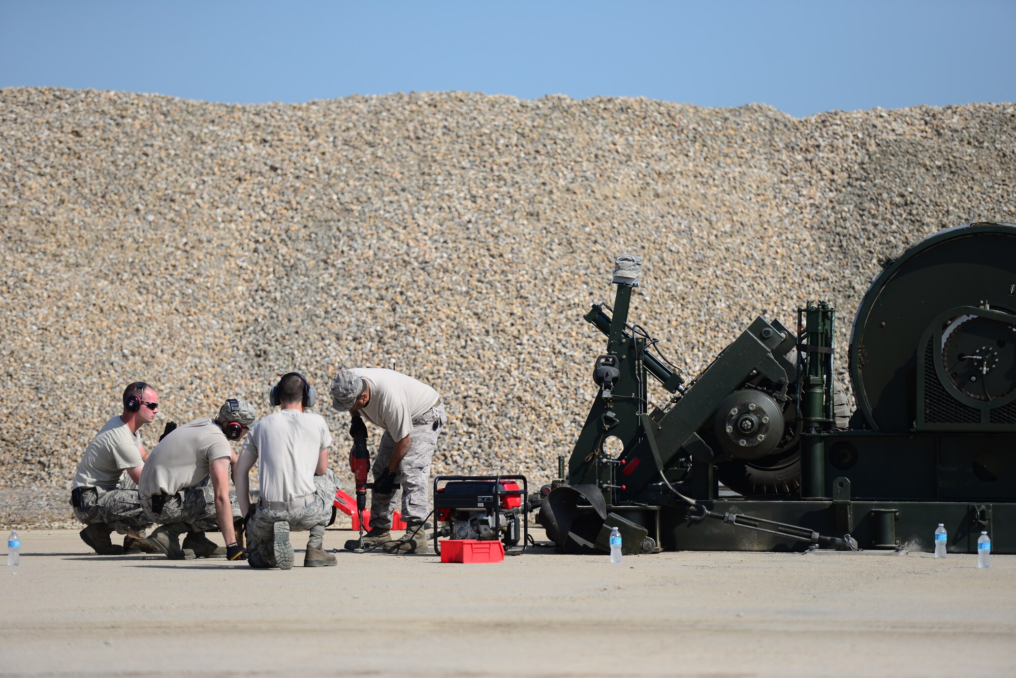 Airmen from the 51st Civil Engineer Squadron power production shop, install a mobile aircraft arresting system during airfield damage repair training at Osan Air Base, Republic of Korea, Aug. 18, 2015. The MAAS uses a system of nylon tapes, reels, chains and sprockets to slow an approaching aircraft’s speed so they can safely cross the newly repaired section of runway. 
(U.S. Air Force photo/Staff Sgt. Amber Grimm)