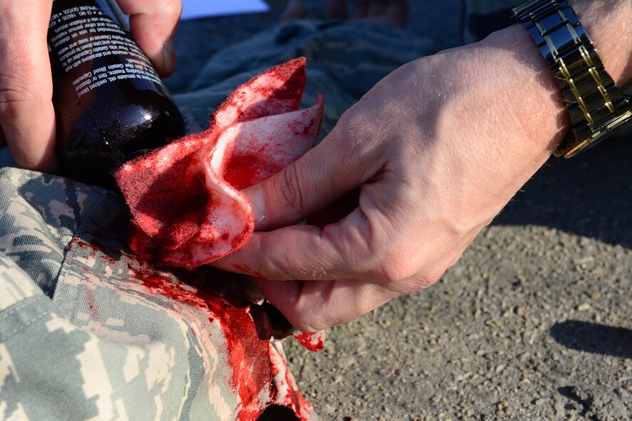 U.S Air Force Master Sgt. Timothy Nelson, 8th Medical Operations Squadron flight chief, pours fake blood on a casualty roleplayer in preparation for a mass casualty exercise as part of Beverly Pack 16-1 at Kunsan Air Base, Republic of Korea, Oct. 6, 2015. The exercise tested the efficiency and response time for Airmen performing self-aid and buddy care. (U.S. Air Force photo by Senior Airman Ashley L. Gardner/Released)

