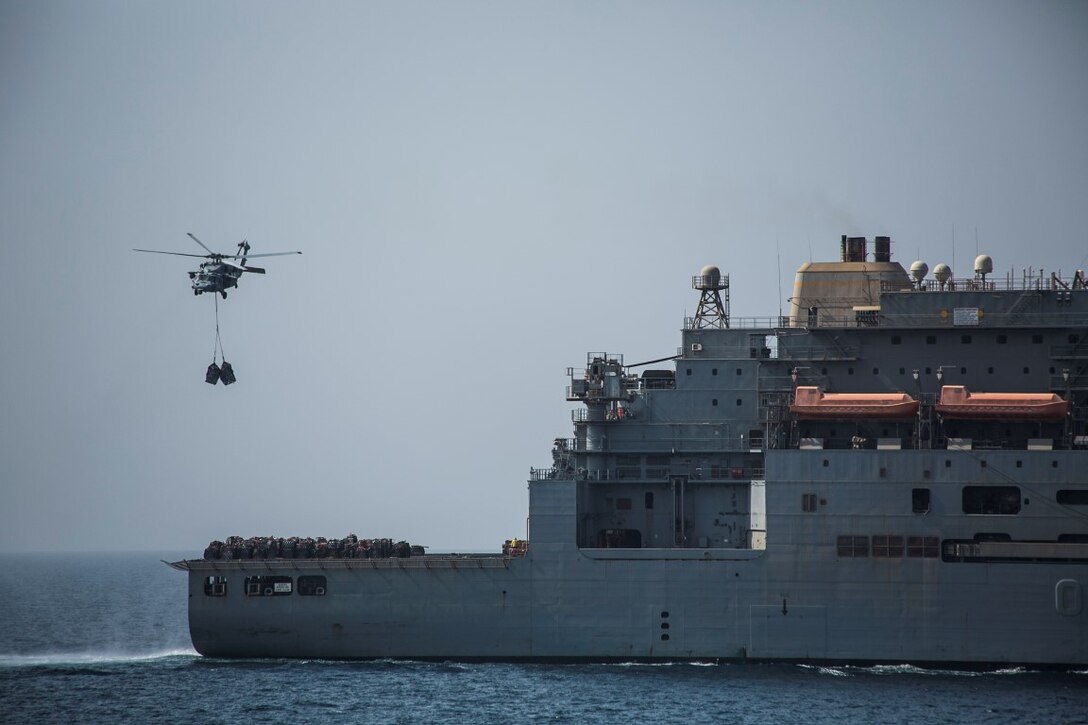 ARABIAN GULF (Oct. 7, 2015) An MH-60S Sea Hawk transports pallets from the USNS Patuxent (T-AO 201) to the amphibious assault ship USS Essex (LHD 2) during a replenishment-at-sea. U.S. Marines with the 15th Marine Expeditionary Unit and Sailors with the Essex Amphibious Ready Group worked together to distribute the supplies throughout the ship. The 15th MEU, embarked aboard the ships of the Essex ARG, is deployed to maintain regional security in the U.S. 5th Fleet area of operations. (U.S. Marine Corps photo by Cpl. Anna Albrecht/Released)