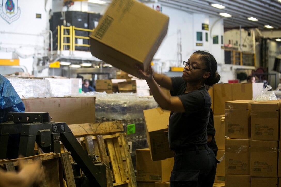 ARABIAN GULF (Oct. 7, 2015) A U.S. Sailor aboard the amphibious assault ship USS Essex (LHD 2) passes a box of supplies during a replenishment-at-sea. U.S. Marines with the 15th Marine Expeditionary Unit and Sailors with the Essex Amphibious Ready Group worked together to distribute the supplies throughout the ship. The 15th MEU, embarked aboard the ships of the Essex ARG, is deployed to maintain regional security in the U.S. 5th Fleet area of operations. (U.S. Marine Corps photo by Cpl. Anna Albrecht/Released)