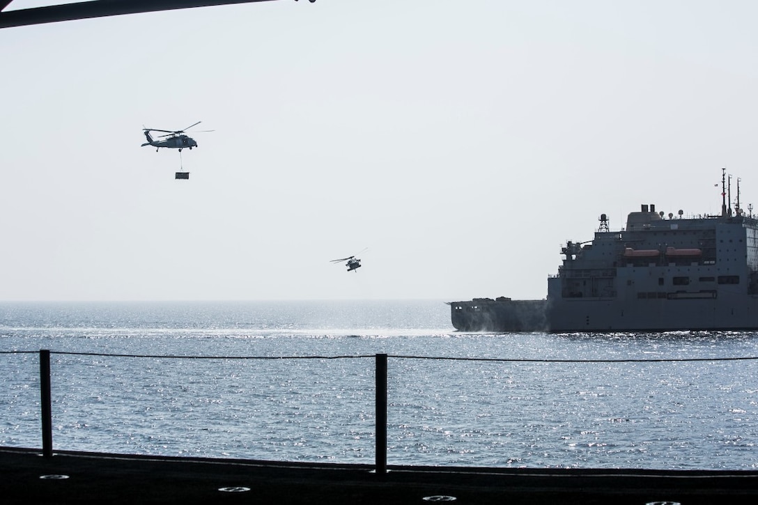 ARABIAN GULF (Oct. 7, 2015) MH-60S Sea Hawks transport pallets from the USNS Patuxent (T-AO 201) to the amphibious assault ship USS Essex (LHD 2) during a replenishment-at-sea. U.S. Marines with the 15th Marine Expeditionary Unit and Sailors with the Essex Amphibious Ready Group worked together to distribute the supplies throughout the ship. The 15th MEU, embarked aboard the ships of the Essex ARG, is deployed to maintain regional security in the U.S. 5th Fleet area of operations. (U.S. Marine Corps photo by Cpl. Anna Albrecht/Released)