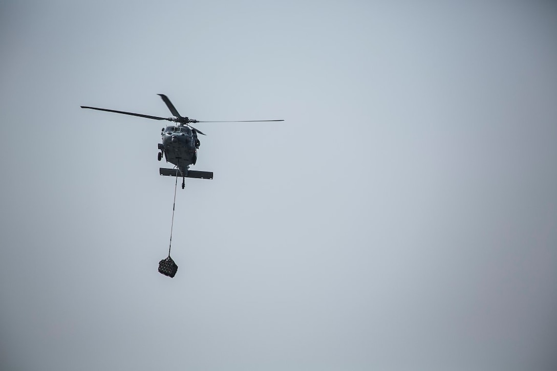 ARABIAN GULF (Oct. 7, 2015) An MH-60S Sea Hawk transports pallets to the amphibious assault ship USS Essex (LHD 2) during a replenishment-at-sea. U.S. Marines with the 15th Marine Expeditionary Unit and Sailors with the Essex Amphibious Ready Group worked together to distribute the supplies throughout the ship. The 15th MEU, embarked aboard the ships of the Essex ARG, is deployed to maintain regional security in the U.S. 5th Fleet area of operations. (U.S. Marine Corps photo by Cpl. Anna Albrecht/Released)