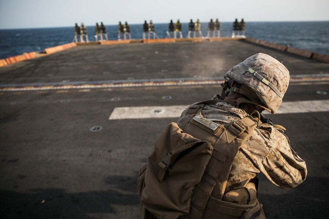 ARABIAN GULF (Oct. 10, 2015) U.S. Marine Lance Cpl. Albert Cerda fires at his target during a deck shoot aboard the amphibious assault ship USS Essex (LHD 2). Cerda is a rifleman with Lima Company, Battalion Landing Team 3rd Battalion, 1st Marine Regiment, 15th Marine Expeditionary Unit. The Marines ran and grappled between their shooting to raise their heart rate and practice shooting while their bodies were fatigued. The 15th MEU, embarked aboard the ships of the Essex ARG, is deployed to maintain regional security in the U.S. 5th Fleet area of operations. (U.S. Marine Corps photo by Cpl. Anna Albrecht/Released)