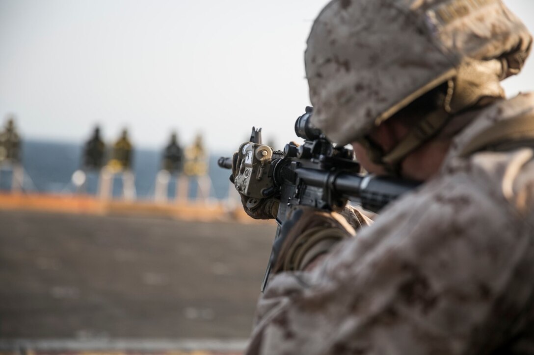 ARABIAN GULF (Oct. 10, 2015) A U.S. Marine with Lima Company, Battalion Landing Team 3rd Battalion, 1st Marine Regiment, 15th Marine Expeditionary Unit, aims at his target during a deck shoot aboard the amphibious assault ship USS Essex (LHD 2). The Marines ran and grappled between their shooting to raise their heart rate and practice shooting while their bodies were fatigued. The 15th MEU, embarked aboard the ships of the Essex ARG, is deployed to maintain regional security in the U.S. 5th Fleet area of operations. (U.S. Marine Corps photo by Cpl. Anna Albrecht/Released)