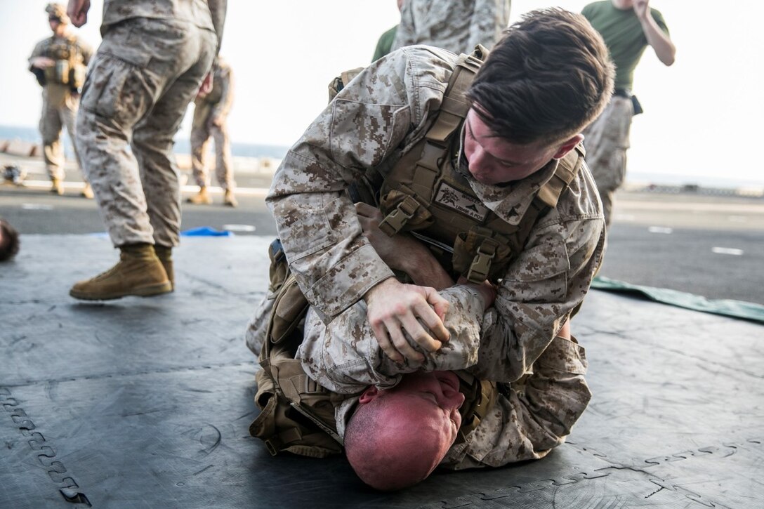 ARABIAN GULF (Oct. 10, 2015) U.S. Marines with Lima Company, Battalion Landing Team 3rd Battalion, 1st Marine Regiment, 15th Marine Expeditionary Unit, grapple during a deck shoot aboard the amphibious assault ship USS Essex (LHD 2). The Marines ran and grappled between their shooting to raise their heart rate and practice shooting while their bodies were fatigued. The 15th MEU, embarked aboard the ships of the Essex ARG, is deployed to maintain regional security in the U.S. 5th Fleet area of operations. (U.S. Marine Corps photo by Cpl. Anna Albrecht/Released)