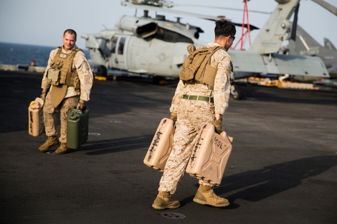 ARABIAN GULF (Oct. 10, 2015) U.S. Marines with Lima Company, Battalion Landing Team 3rd Battalion, 1st Marine Regiment, 15th Marine Expeditionary Unit, run with water jugs during a deck shoot aboard the amphibious assault ship USS Essex (LHD 2). The Marines ran and grappled between their shooting to raise their heart rate and practice shooting while their bodies were fatigued. The 15th MEU, embarked aboard the ships of the Essex ARG, is deployed to maintain regional security in the U.S. 5th Fleet area of operations. (U.S. Marine Corps photo by Cpl. Anna Albrecht/Released)