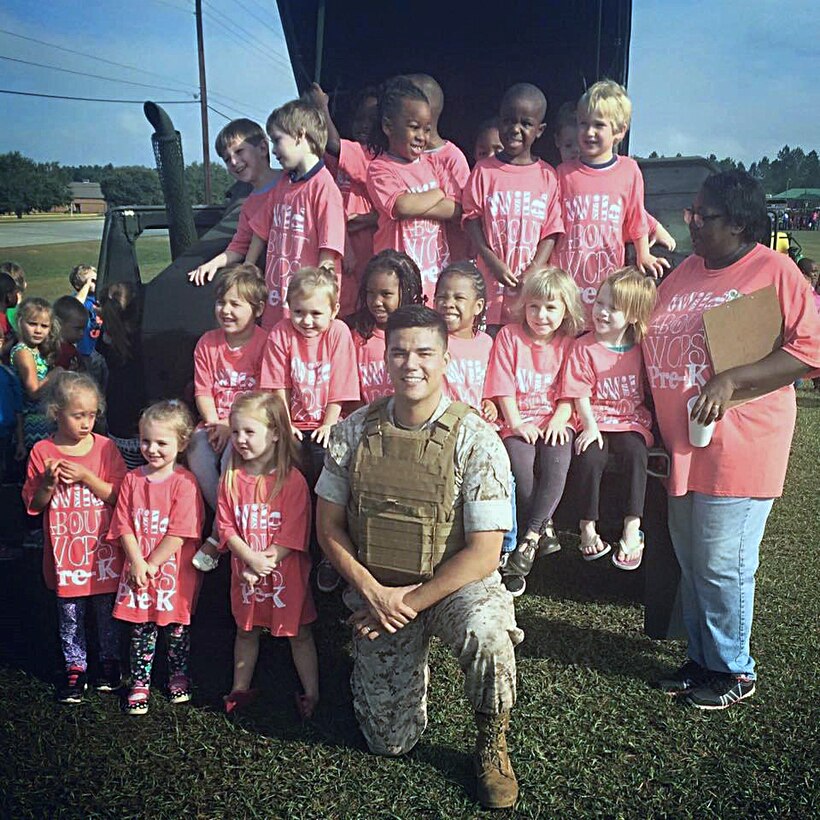 Sgt. Thomas Over, platoon sergeant, and Cpl. Devante Mimms, licensing noncommissioned  officer, both with Logistics Support Division, Marine Corps Logistics Base Albany, volunteer to support the annual Transportation Day event at Worth County Primary School in Sylvester, Ga., Oct. 9. They drove a high mobility multi-wheeled vehicle to the school for the students to see, touch and learn about.