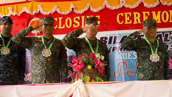 U.S. and Philippine service members salute  at the ribbon cutting ceremony Oct. 8, during Amphibious Landing Exercise 2015. PHIBLEX is an annual, bilateral training exercise conducted by members of the Armed Forces of the Philippines alongside U.S. Marine and Navy Forces. It focuses on strengthening the partnership and relationships between the two nations across a range of military operations, including disaster relief and complex expeditionary operations. The ribbon cutting ceremony signified the end of the Humanitarian Civic Assistance projects at the Concepcion and Binduyan Elementary schools. 