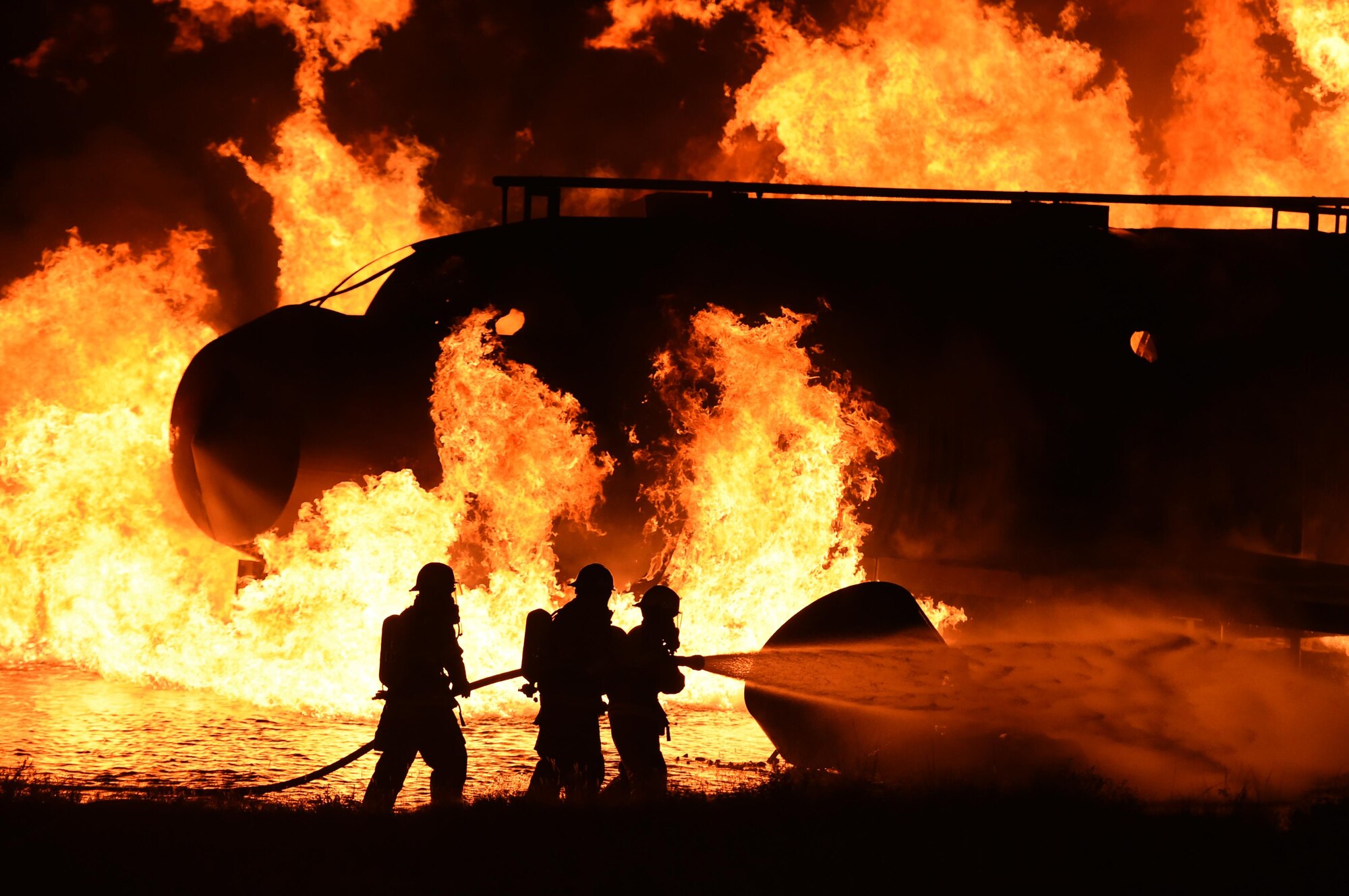 ALTUS AIR FORCE BASE, Okla. – U.S. Air Force Col. Todd Hohn, 97th Air Mobility Wing commander, and members of the 97th Civil Engineer Squadron Fire Department extinguish a fire during a firefighting demonstration, Oct. 7 at the live-fire training area. The demonstration allowed members of the base to get a first-hand look at how the Altus AFB firefighters train for emergency responses. (U.S. Air Force photo by Senior Airman Dillon Davis/Released)