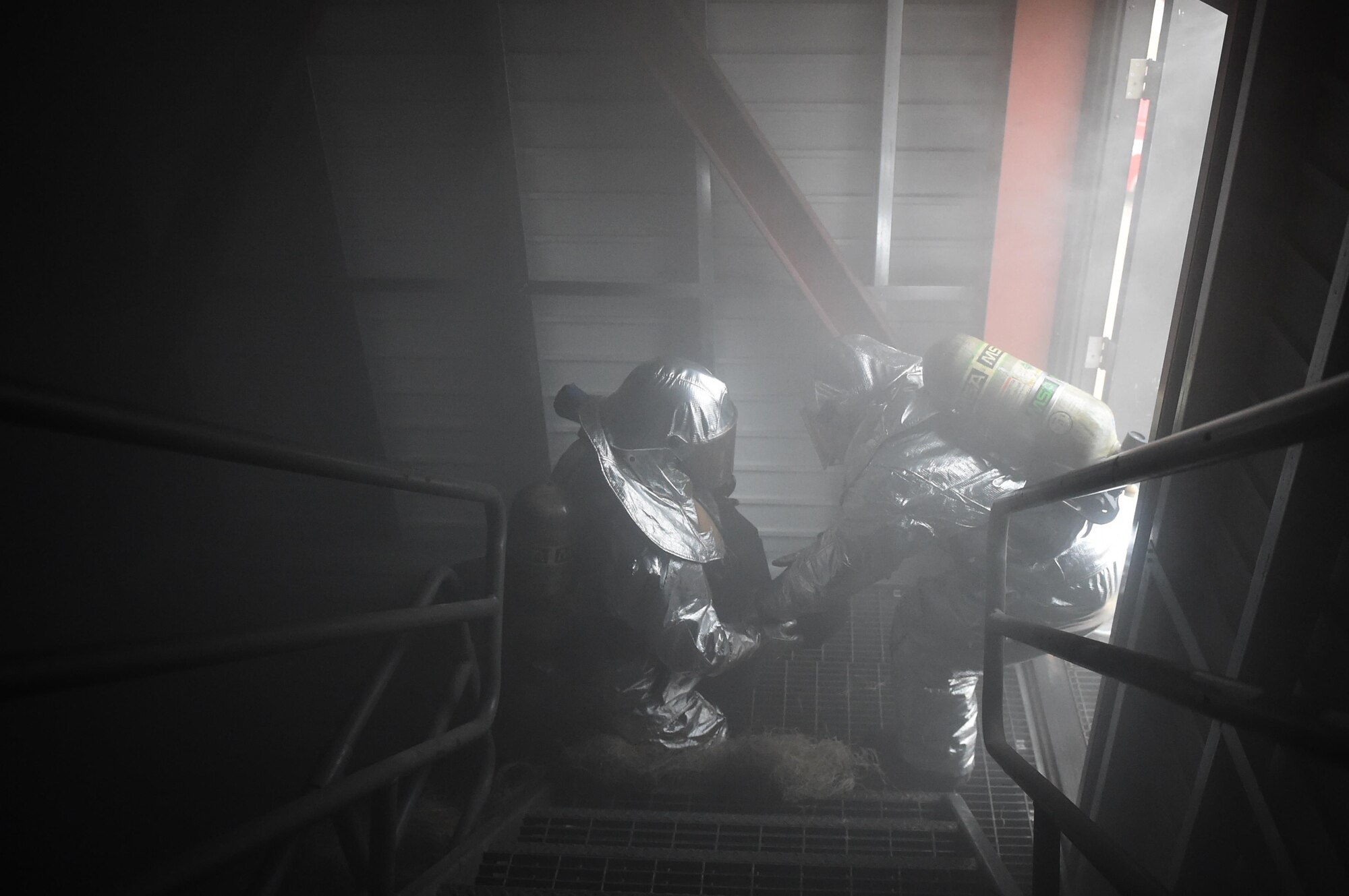 ALTUS AIR FORCE BASE, Okla. – Airmen from the 97th Air Mobility Wing drag a dummy out of a smoky building during the Annual Group Commander and Chiefs Firefighter Challenge, Oct. 9 at the live-fire training area. This year’s challenge had commanders and chiefs run into a dark, smoky room to locate and rescue a weighted dummy. (U.S. Air Force photo by Senior Airman Dillon Davis/Released)