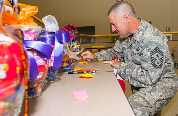 Chief Master Sgt Troy Eden, National Air and Space Intelligence Center command chief, makes his estimates for the candy jar guessing game during the center's annual Combined Federal Capaign kick-off event here, Friday, Oct. 9, 2015. The CFC, established by the federal government in 1961, is the only authorized charitable fundraising campaign for federal employees, both civilian and military. (U.S. Air Force photo by Tech. Sgt. Eunique Thomas)