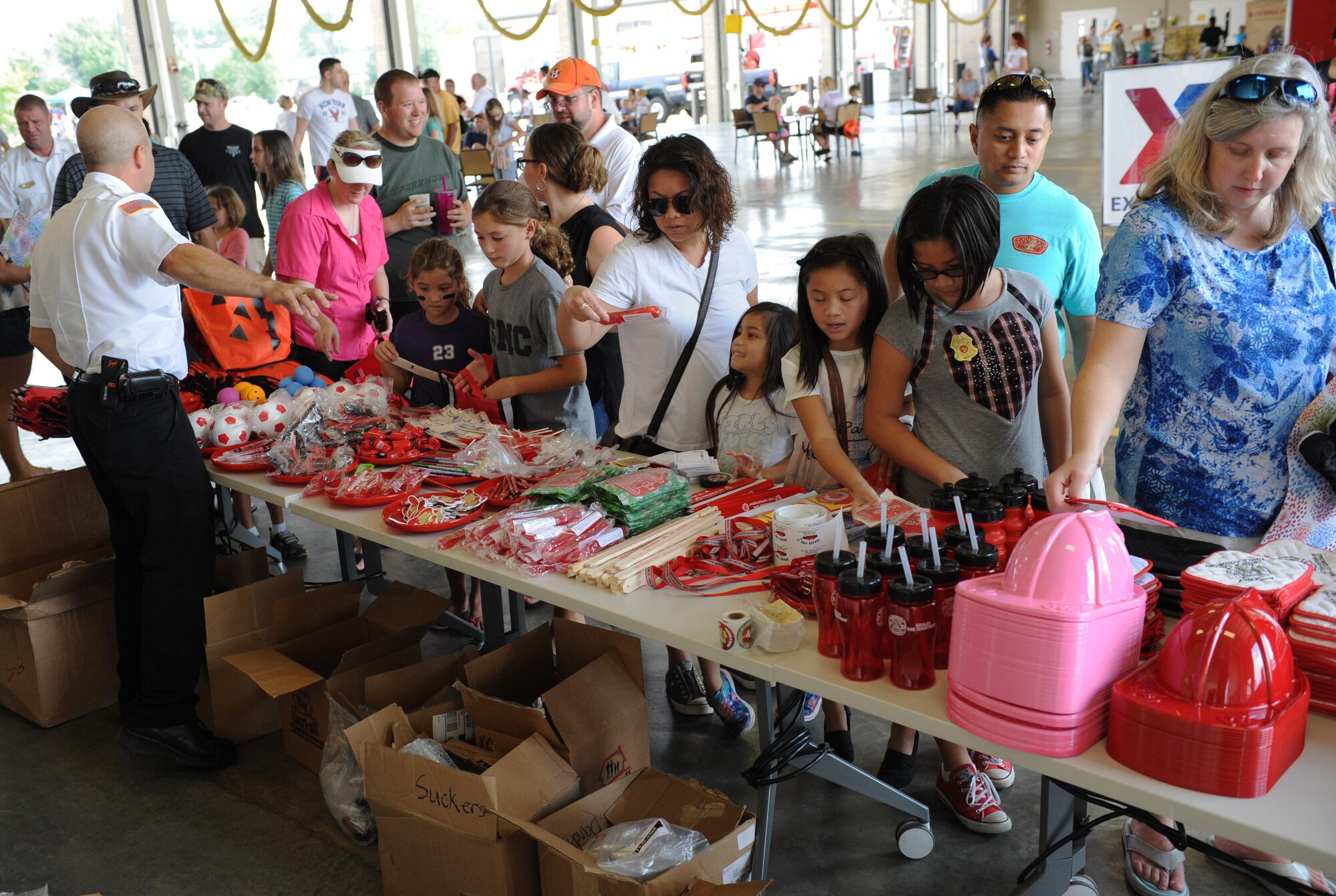 Keesler families collect gifts during the Keesler Fire Department open house at the fire station Oct. 10, 2015, Keesler Air Force Base, Miss. The open house was the conclusion event to Fire Prevention Week. Throughout the week the Keesler Fire Department conducted random fire drills, toured various facilities with Sparky the Fire Dog, passed out fire safety information and fire hats for children and provided stove and fire extinguisher demonstrations. (U.S. Air Force photo by Kemberly Groue)