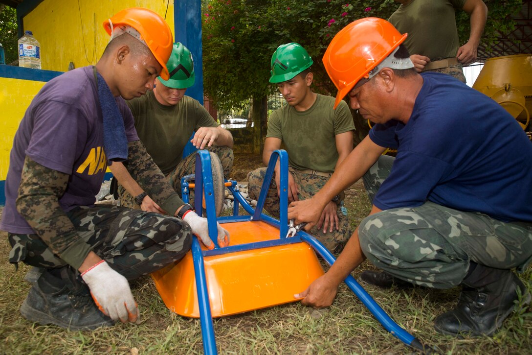 Philippine Navy Seabees, members of their naval construction battalions,  and U.S. Marines work together to fix a wheelbarrow while preparing to begin working on the humanitarian civic assistance project at Concepcion Elementary School Sept. 24, during Amphibious Landing Exercise 2015 (PHIBLEX 15). PHIBLEX 15 is an annual, bilateral training exercise conducted by members of the Armed Forces of the Philippines alongside U.S. Marine and Navy Forces. It focuses on strengthening the partnership and relationships between the two nations across a range of military operations, including disaster relief and complex expeditionary operations. The Marines are with 9th Engineer Support Battalion, 3rd Marine Logistics Group, III Marine Expeditionary Force.