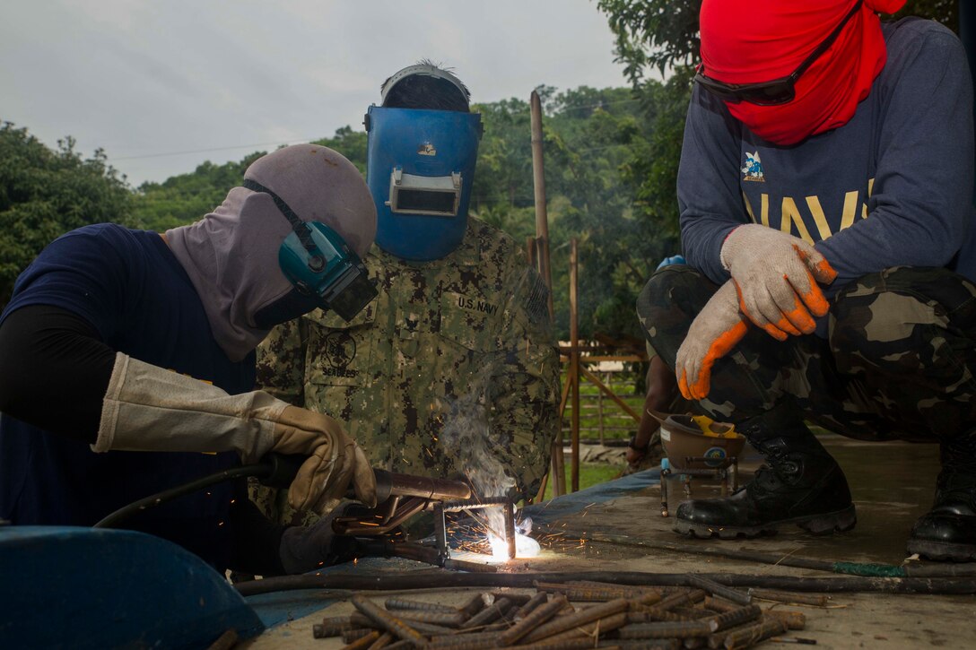 Philippine and a U.S. Navy Seabees, members of their naval construction battalions, weld together rebar while working on the humanitarian civic assistance project at Concepcion Elementary School Sept. 25, during Amphibious Landing Exercise 2015 (PHIBLEX 15). PHIBLEX 15 is an annual, bilateral training exercise conducted by members of the Armed Forces of the Philippines alongside U.S. Marine and Navy Forces. It focuses on strengthening the partnership and relationships between the two nations across a range of military operations, including disaster relief and complex expeditionary operations. The welded rebar will act as braces for the support beams that will be used to support an overhang.