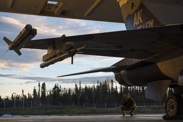 Senior Airman Terrence Lawrence, a 354th Aircraft Maintenance Squadron aircraft electrical and environmental systems journeyman, prepares an F-16 Fighting Falcon, assigned to the 18th Aggressor Squadron, for a mission at Eielson Air Force Base, Alaska, Oct. 8, 2015. Lawrence was the first Airman to complete a program called Cut Training, which cross utilizes Airmen to fill undermanned crew chief positions. (U.S. Air Force photo/Staff Sgt. Joshua Turner) 