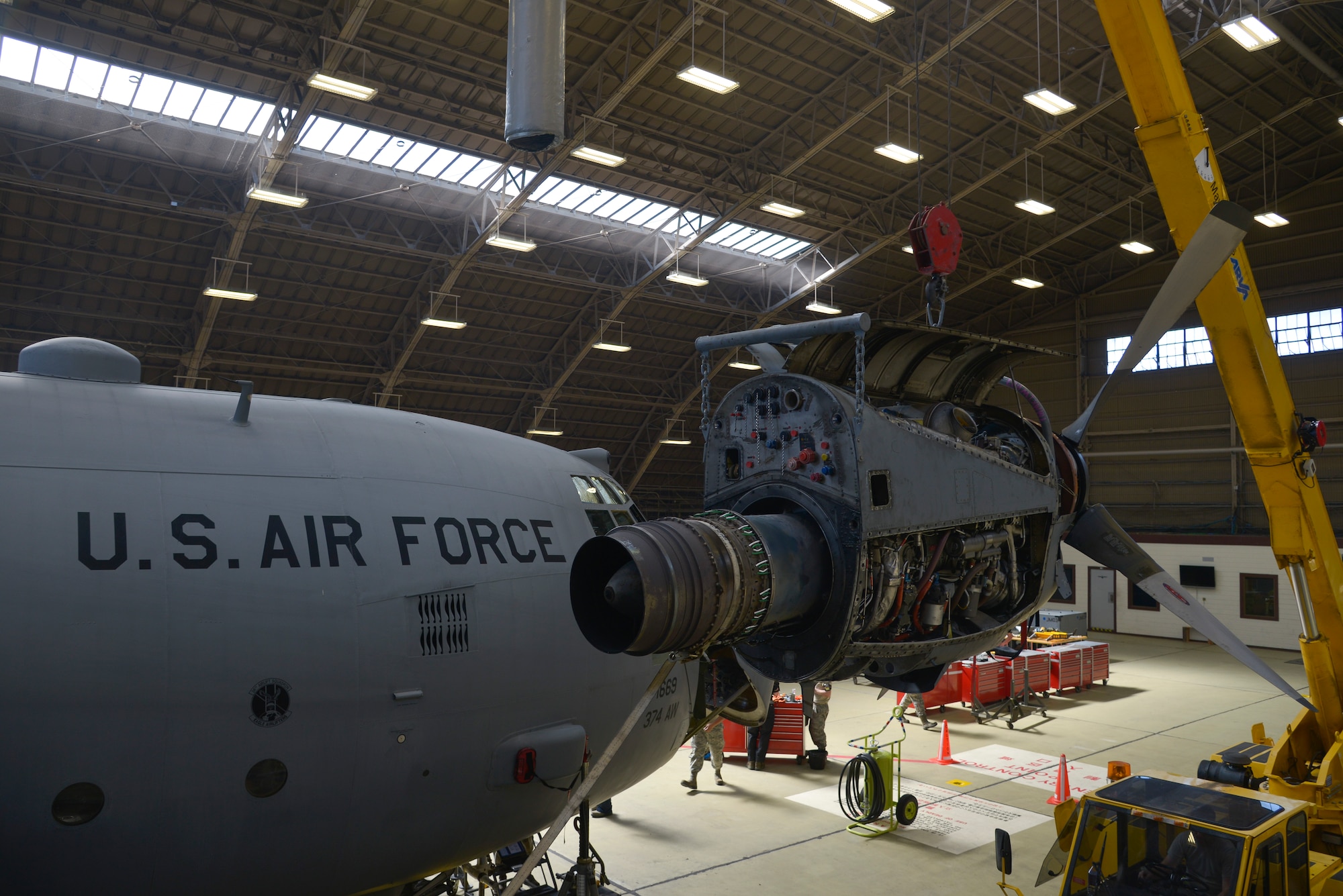 A C-130 Hercules’s engine and propeller hangs mid-air until Airmen are ready to place it into a cart for inspection at Yokota Air Base, Japan, Oct. 8, 2015. The new paperless process has saved approximately 600 man-hours per isochronal inspection. (U.S. Air Force photo by Senior Airman David Owsianka/Released)