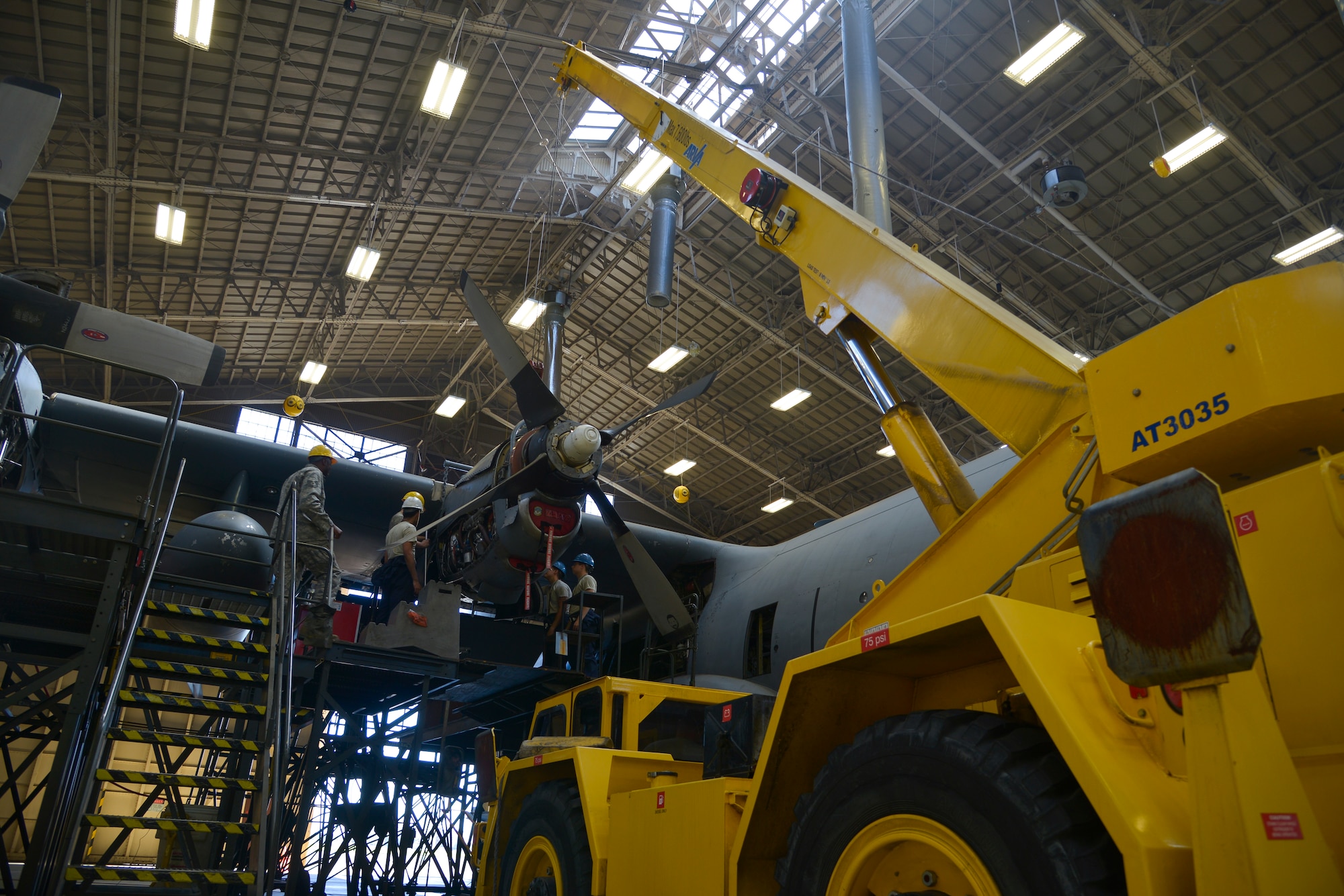 Members of the 374th Maintenance Squadron prepare to remove a C-130 Hercules propeller at Yokota Air Base, Japan, Oct. 8, 2015. Every 540 days a C-130 Hercules enters the phase docks for an inspection. (U.S. Air Force photo by Senior Airman David Owsianka/Released)