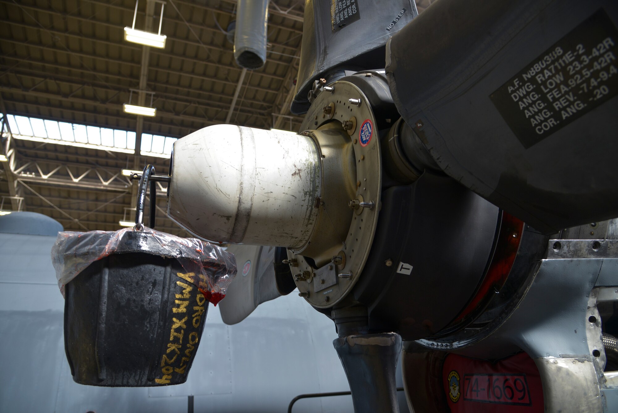 A bucket filled with hydraulic fluid hangs from part of a C-130 Hercules propeller at Yokota Air Base, Japan, Oct. 8, 2015. During the 14-day phase dock process, Airmen inspect the aircraft and fix approximately 1,000 discrepancies. (U.S. Air Force photo by Senior Airman David Owsianka/Released)