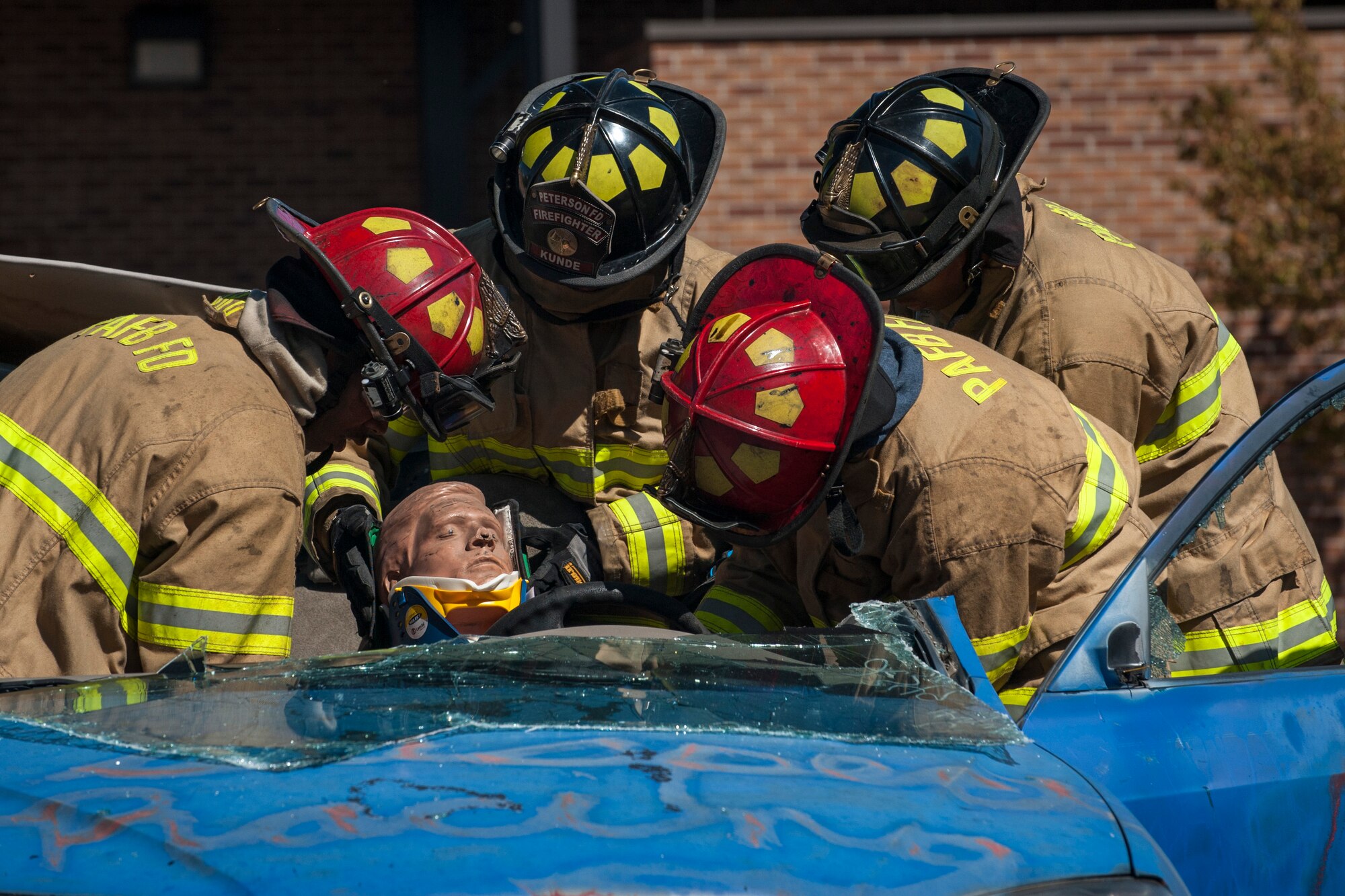 PETERSON AIR FORCE BASE, Colo. – 21st Civil Engineer Squadron fire fighters put a neck brace on a trapped dummy after removing the roof of the car as part of a vehicle extrication demonstration at the open house Oct. 3, 2015 at the Peterson Air Force Base Fire Station. The open house provided demonstrations and hands-on learning experiences for attendees to kick off National Fire Prevention Week. (U.S. Air Force photo by Senior Airman Rose Gudex)