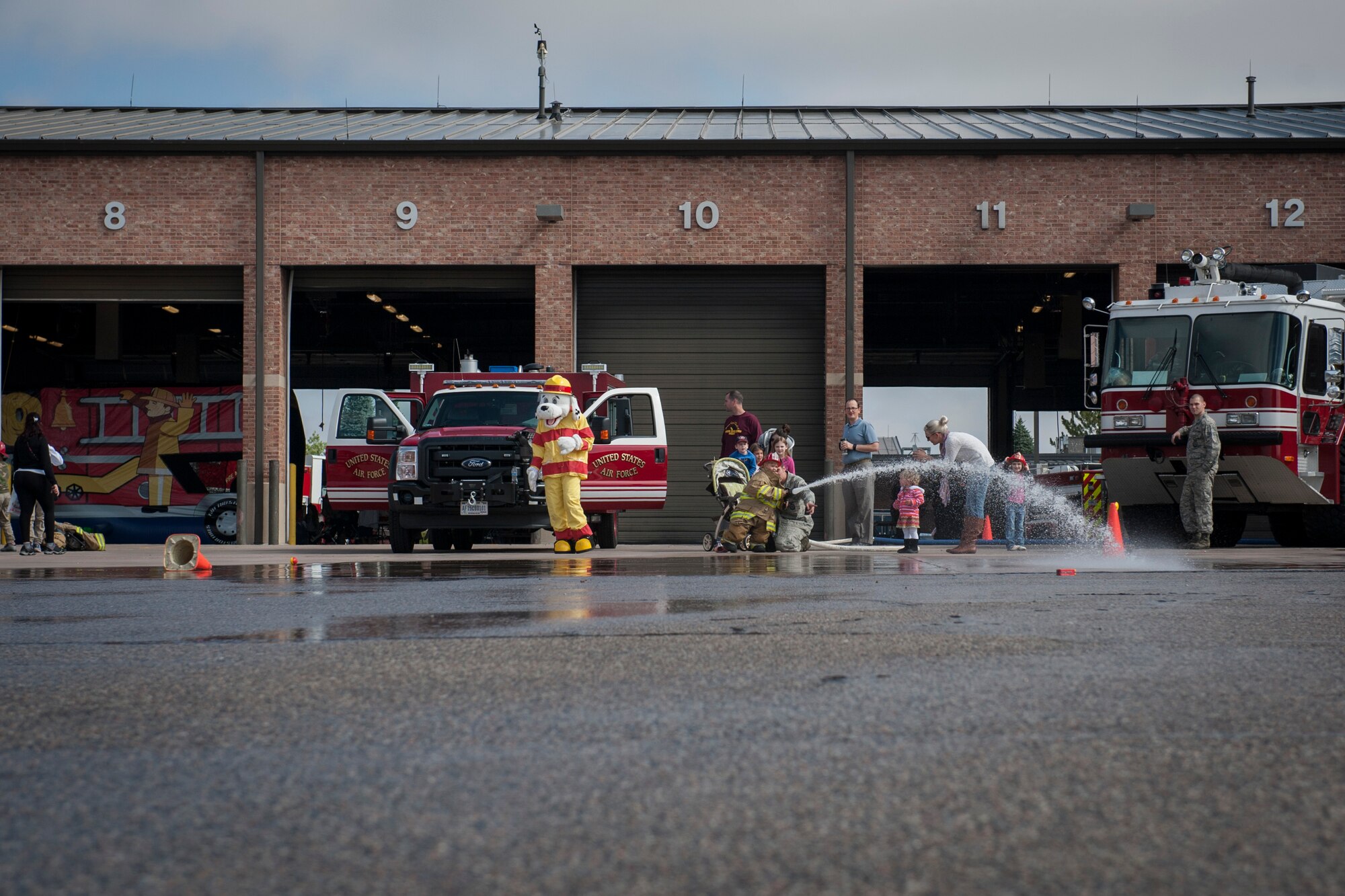 PETERSON AIR FORCE BASE, Colo. – Children of Peterson Airmen spray the fire house at the Peterson Air Force Base Fire Station for their open house Oct. 3, 2015. The event kicked-off National Fire Prevention Week and gave kids a better understanding of the importance of fire safety. The theme this year is “hear the BEEP where you SLEEP.” (U.S. Air Force photo by Senior Airman Rose Gudex)