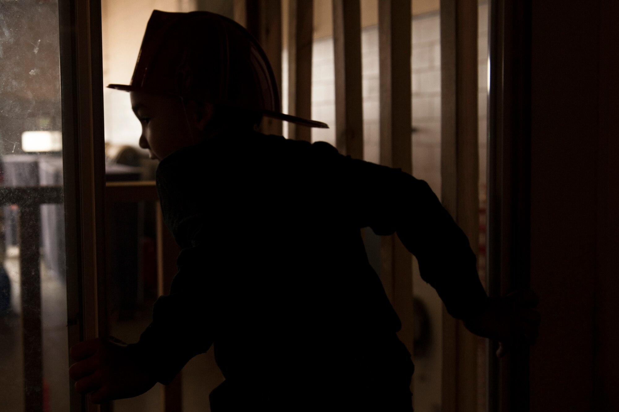 PETERSON AIR FORCE BASE, Colo. – Skyler Robb, 4, climbs out of the upstairs bedroom on the Fire Safety House to escape a theoretical fire at an open house at the Peterson Air Force Base Fire Station, Oct. 3, 2015. The Fire Safety House gives fire fighters a chance to educate children on fire safety and show the importance of having more than one way out of a building. The event kicked-off National Fire Prevention Week. (U.S. Air Force photo by Senior Airman Rose Gudex)