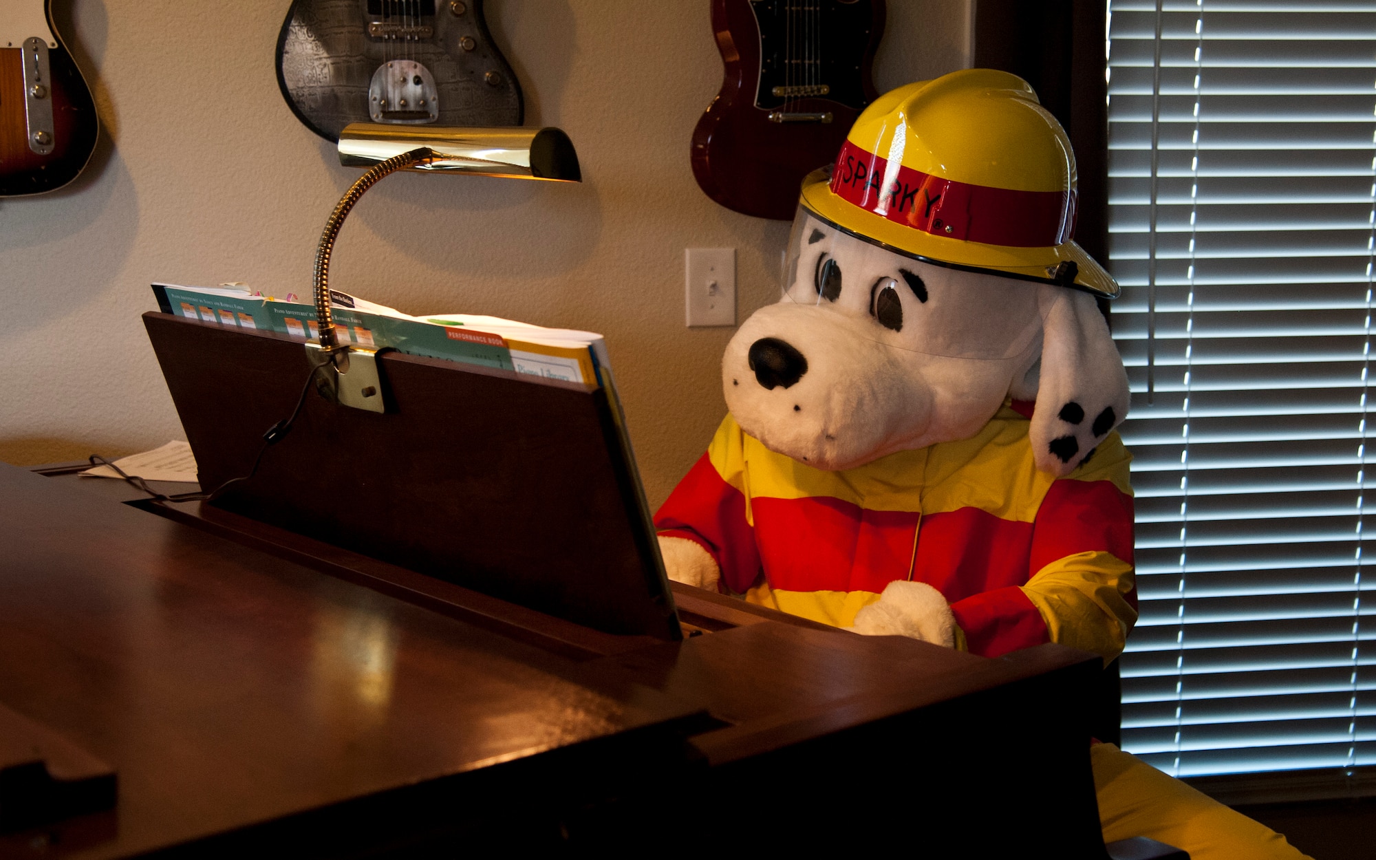 PETERSON AIR FORCE BASE, Colo. – Sparky, the fire dog, plays on Col. Susan Moran’s, 21st Medical Group commander, grand piano during smoke alarm inspection as part of the Fire Prevention Week, Oct. 5, 2015. The fire department along with representatives from Terra Vista and The Club are making visits to Terra Vista residents on Oct. 5, 6 and 9 from 4-8 p.m. to inspect smoke alarms for a chance to win a free pizza. The fire department is also making visits to schools, child development centers and sponsoring a fire muster at The Club to help educate Team Pete and their families on fire safety. (U.S. Air Force photo by Senior Airman Tiffany DeNault)