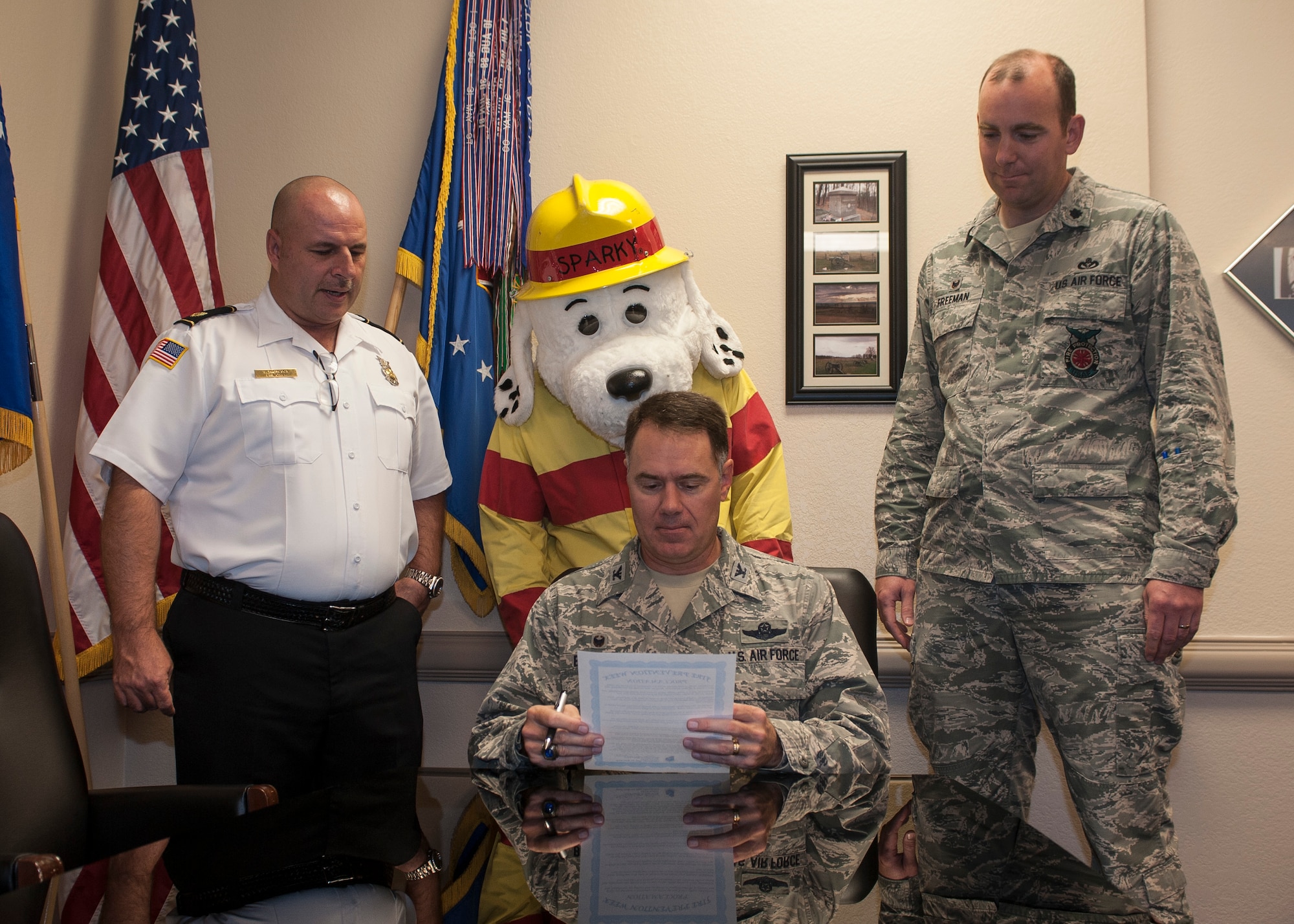 Col. Richard Boutwell (front), 99th Air Base Wing commander, reviews the National Fire Prevention Week proclamation with members of the 99th Civil Engineer Squadron prior to signing it at Nellis Air Force Base, Nev., Oct. 6, 2015. The theme of this year’s National Fire Prevention Week, which brings awareness to fire safety and prevention, is “Hear the Beep Where You Sleep” which encourages individuals to ensure they have a working smoke alarm in every room. (U.S. Air Force photo by Staff Sgt. Siuta B. Ika)