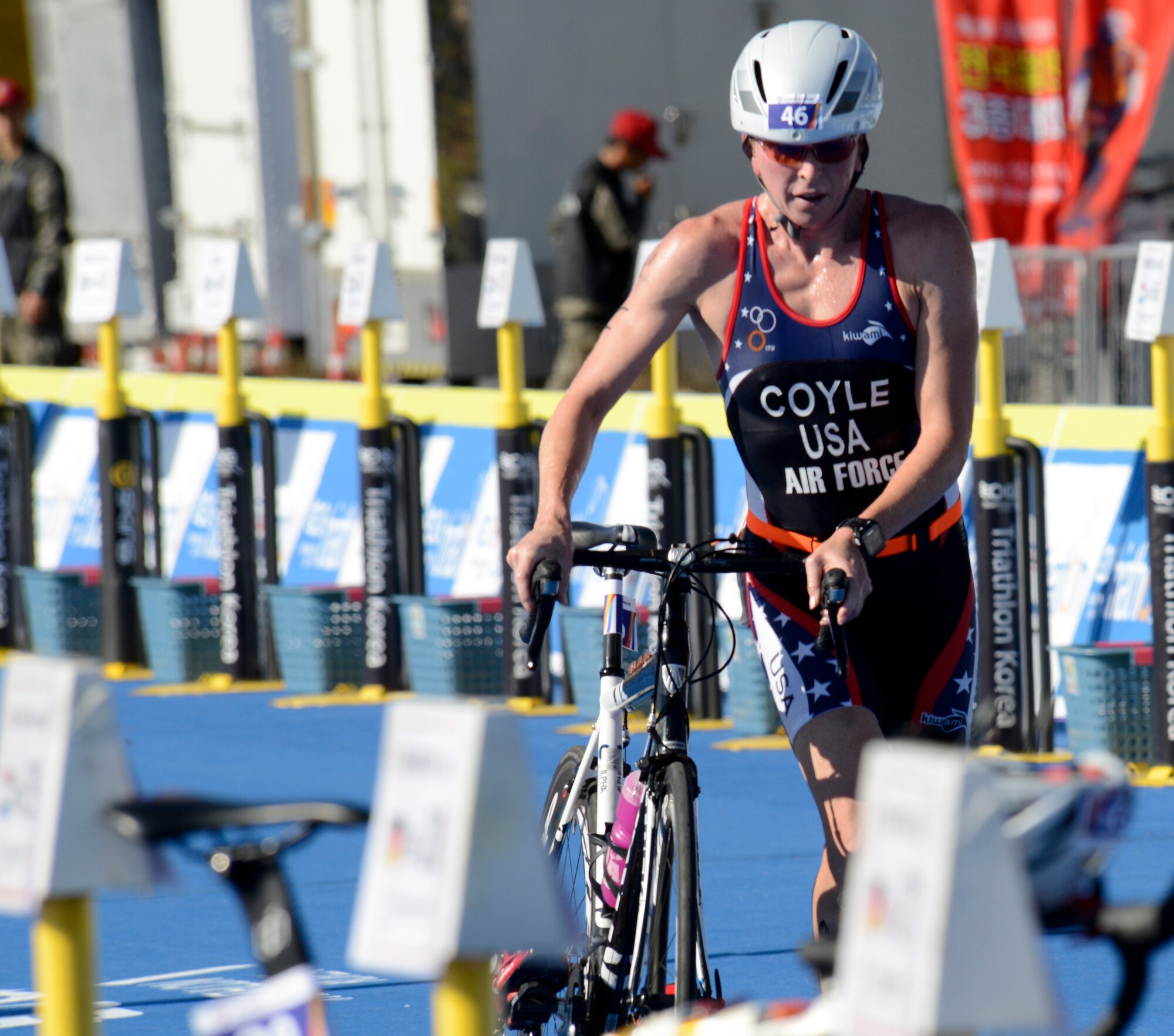 U.S. Air Force Maj. Judith Coyle pulls her bike out of the rack to begin the 40-kilometer cycling leg of the women's triathlon in Pohang, South Korea, during the CISM World Games Oct. 10, 2015. Coyle earned a bronze medal in the women's senior division. (U.S. Armed Forces Sports photo by Gary Sheftick)
