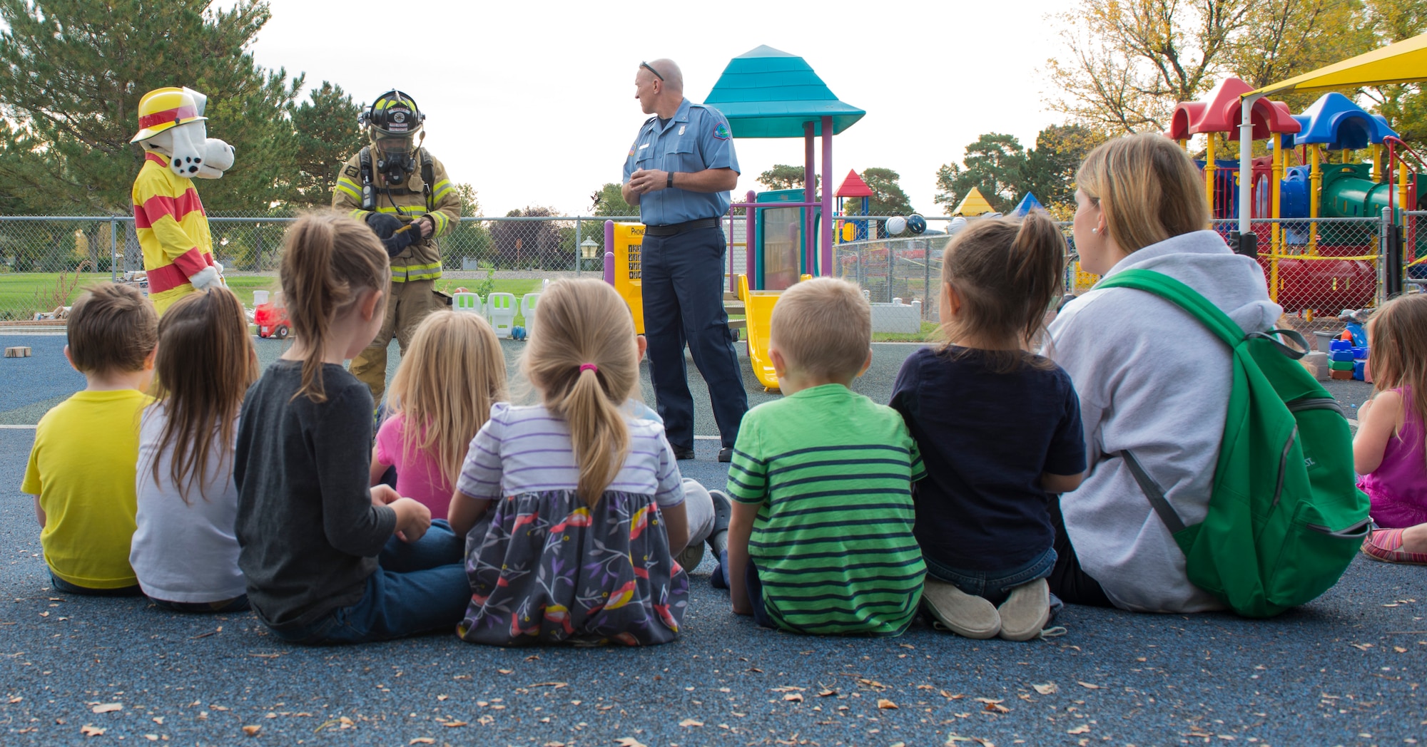 Sparky the Dog and Fire Inspector Brett Perry teach children about 366th Civil Engineer Squadron Firefighter Staff Sgt. Tyler Ford’s fire equipment on Oct. 8, 2015 at the Child Development Center Annex in Mountain Home Air Force Base, Idaho. Their goal was to reach out to the youth on-base, teaching fire safety.  (U.S. Air Force photo by Airman Chester Mientkiewicz)