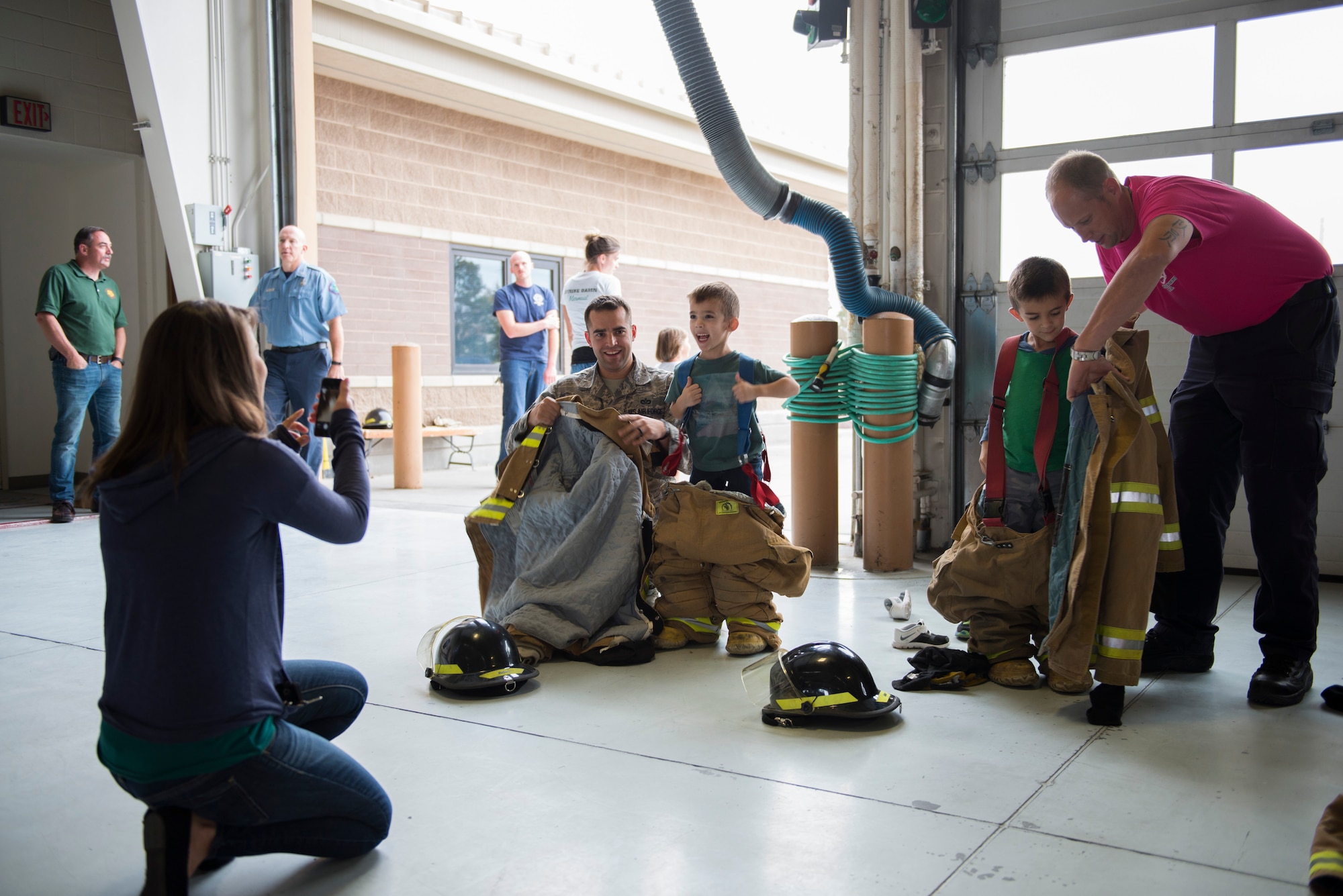Children try on bunker gear during National Fire prevention week in Fire Station 1 Oct. 7, 2015 at Mountain Home Air Force Base, Idaho. The open house gave families the chance to learn fire safety while having fun. (U.S. Air Force photo by Airman Chester Mientkiewicz)