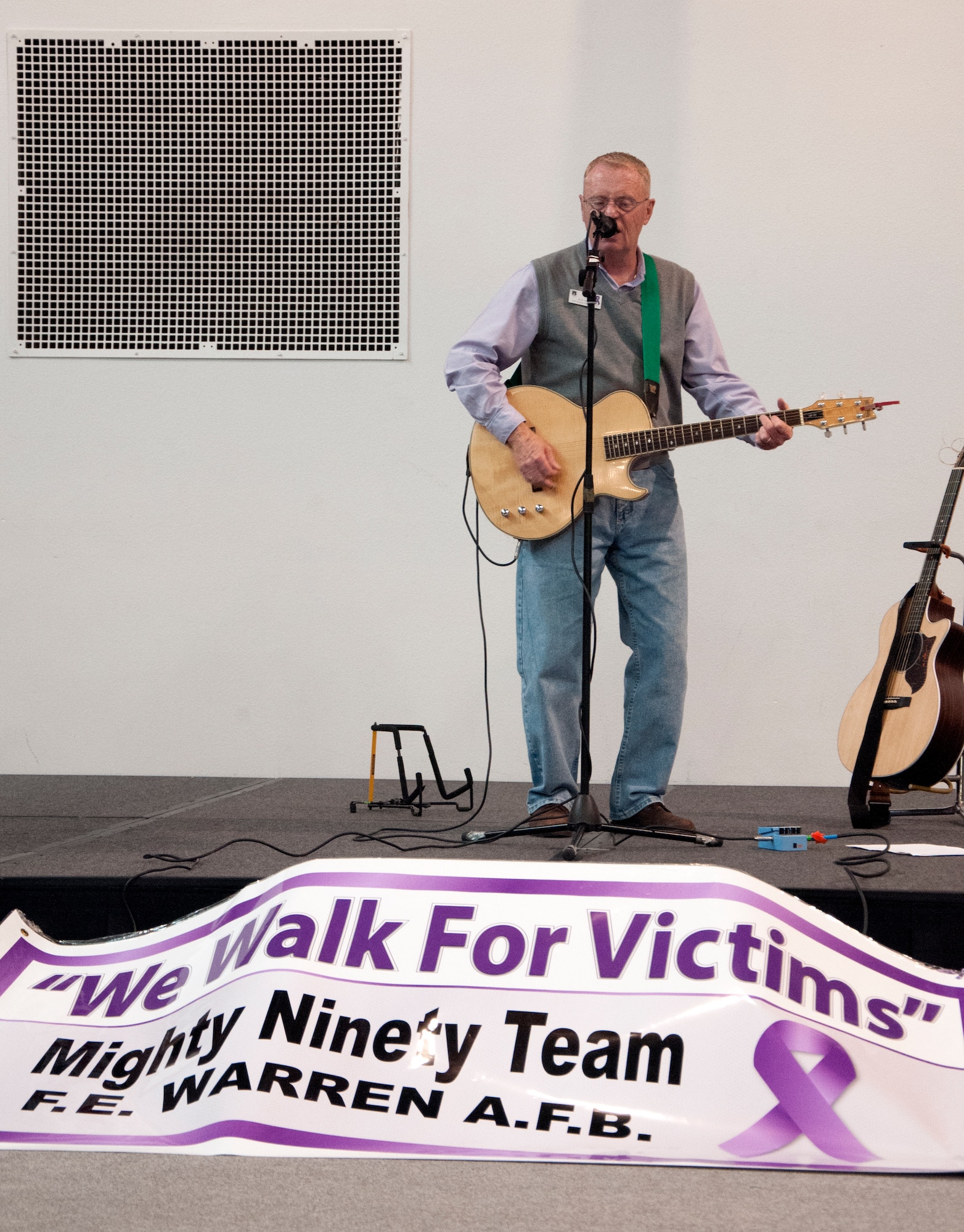 Mark Warner, 90th Missile Wing Protocol office, plays an original song, “Blink of an Eye,” during a domestic violence rally Oct. 9, 2015, in the Fall Hall Community Center on F.E. Warren Air Force Base, Wyo. Warner wrote the song after dealing with a personal experience with domestic violence. (U.S. Air Force photo by Senior Airman Brandon Valle)