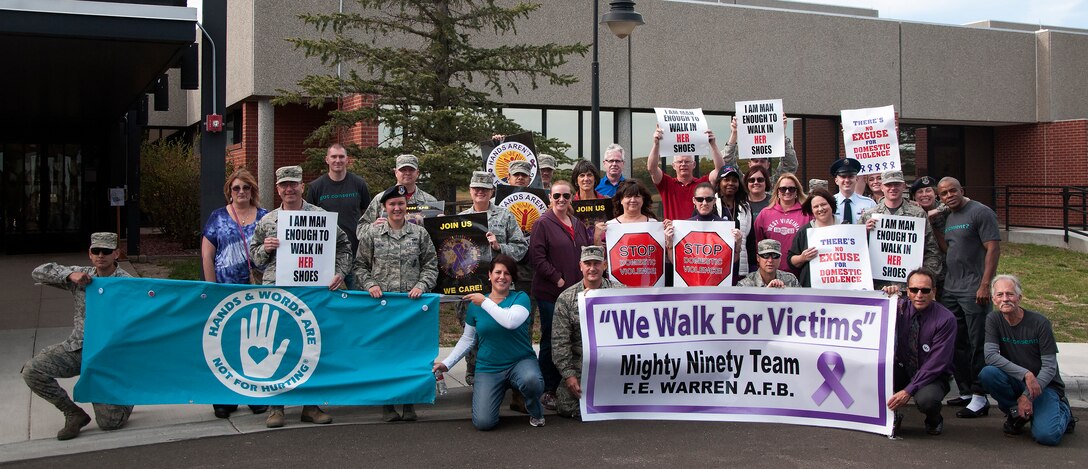 Mighty Ninety Airmen pose near the 90th Medical Group Medical Treatment Facility on F.E. Warren Air Force Base, Wyo., before taking part in a domestic violence walk Oct. 9, 2015. The family advocacy office hosted the event to bring awareness to Airmen on the effects of domestic violence. (U.S. Air Force photo by Senior Airman Brandon Valle)