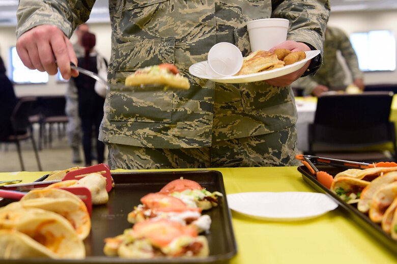Lt. Col. Cynthia Clefisch, 460th Civil Engineer Squadron commander, scoops-up food during the Hispanic Heritage food tasting event Oct. 13, 2015, at the chapel on Buckley Air Force Base, Colo.  The event gave Team Buckley a taste of Hispanic heritage, culture and unique food. The observance month was initiated by President Lyndon Johnson who declared Hispanic Heritage week in 1968, and was later extended to the entire month by President Ronald Regan twenty years later. (U.S. Air Force Photo by Staff Sgt. Stephany Richards) 