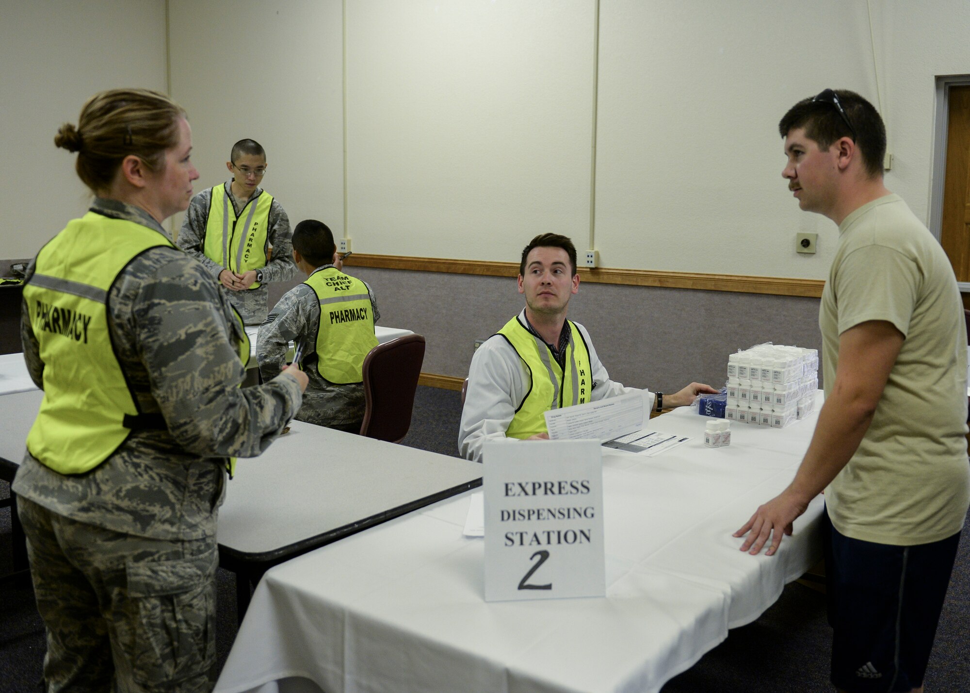 Participants in a public health exercise stand near a point of distribution station at Nellis Air Force Base, Nev., Sept. 30, 2015. The 99th Medical Group conducted a public health exercise on base with local partners in the Clark County area which tested each participant in how they would respond to contracting or deal with individuals who contracted aerosolized tularemia, a serious infection disease which can be used as a biological warfare agent. (U.S. Air Force photo by Airman 1st Class Rachel Loftis)