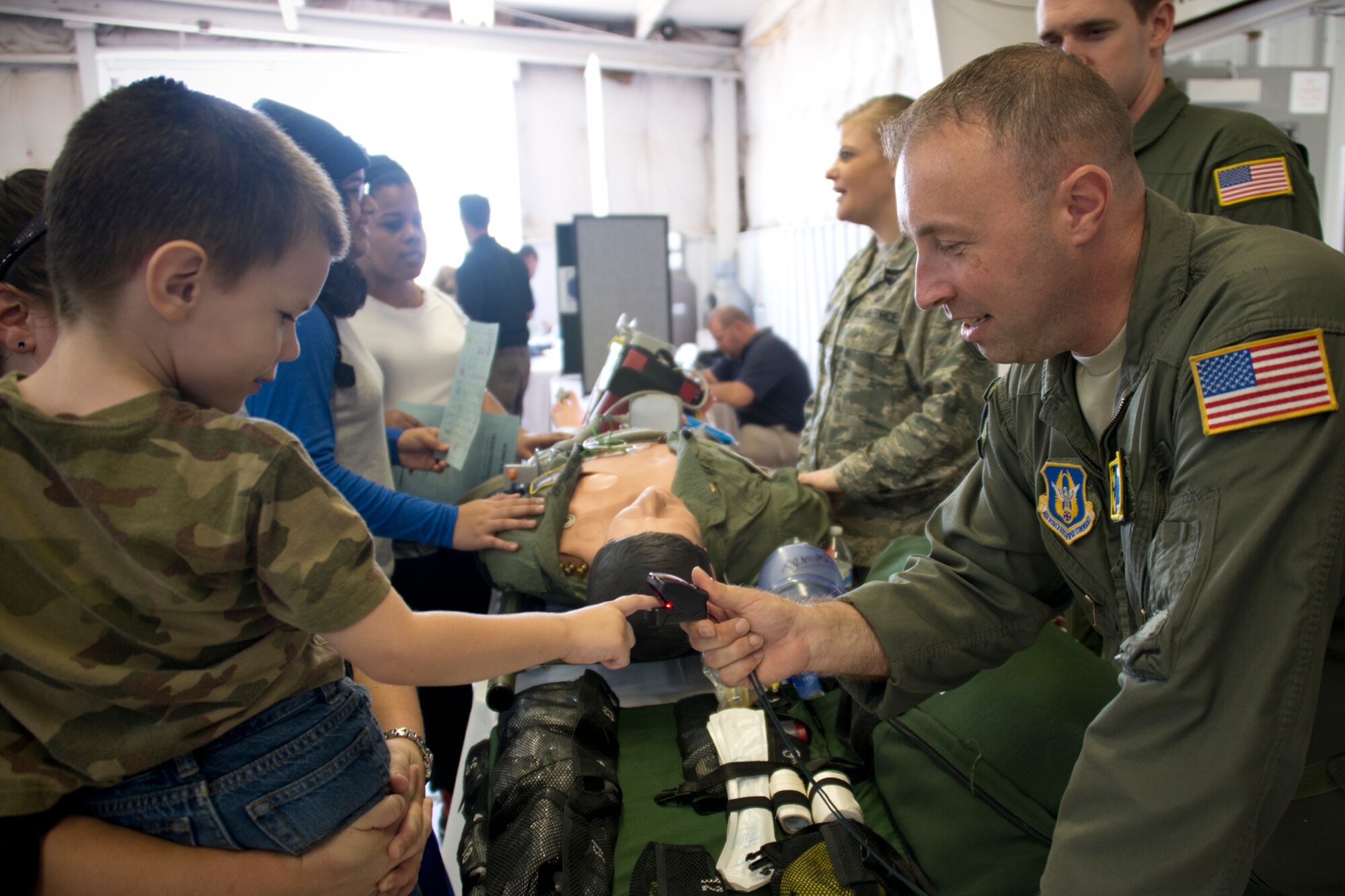 Margaret Kohlbecker's son, David (left), puts his finger in a pulse oximeter held by Tech Sgt. Carl Stewart II, 459th Aeromedical Evacuation Squadron aeromedical evacuation technician (right), at the Virginia Department of Transportation Career Fair at Prince William County Fairgrounds Oct. 8, 2015. The event, which drew more than 1,300 students from the Prince William County area, provided an opportunity for youths to learn about careers in the transportation industry. The 459th was on hand to discuss potential career paths as pilots, boom operators and inflight medics. (U.S. Air Force photo by Staff Sgt. Kat Justen)