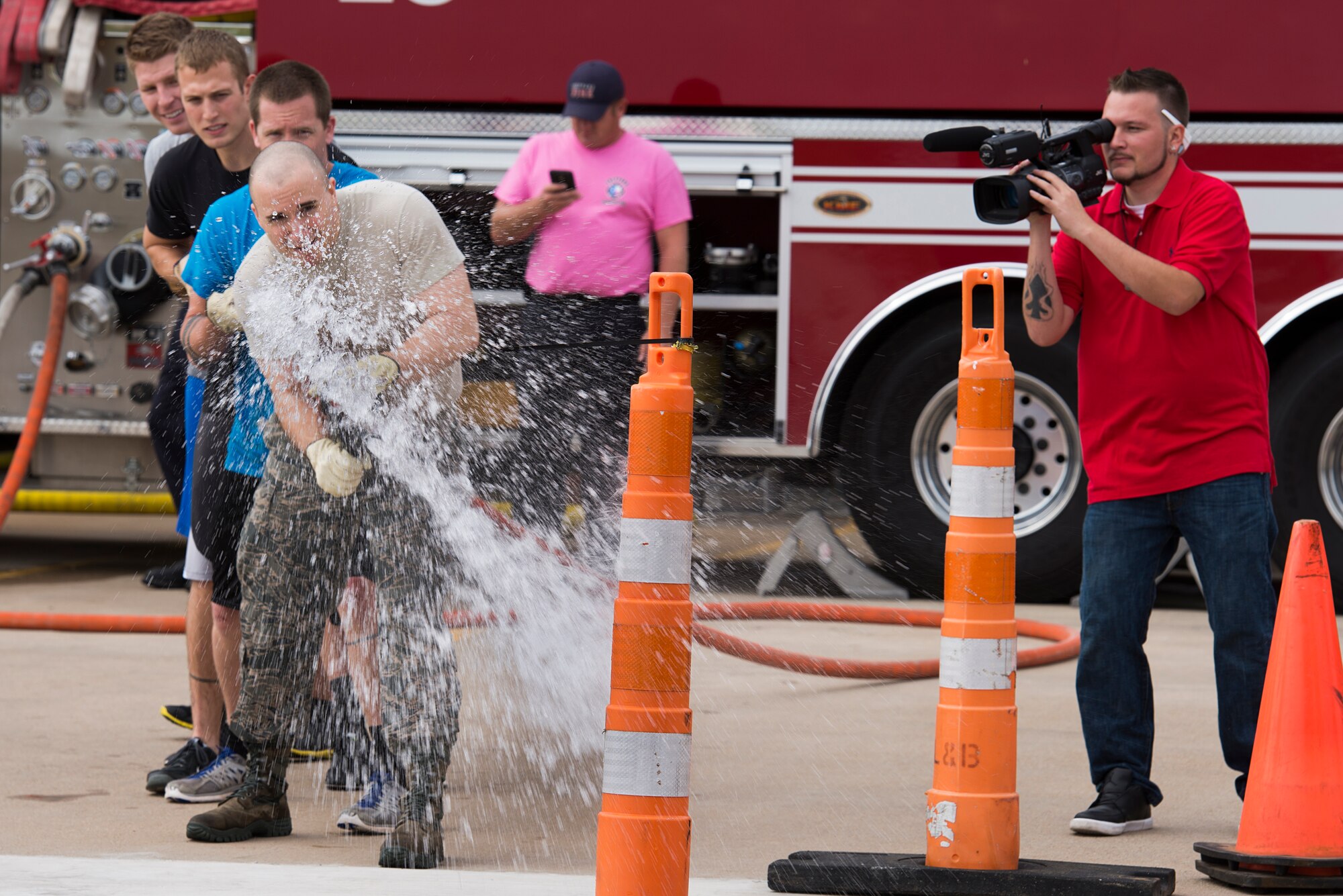 Airmen at Sheppard Air Force Base, Texas, attempt to knock down traffic cones using a fire hose during the 6th Annual Firefighter Olympic Challenge Oct. 9, 2015. The challenge took place during fire prevention week as a means to raise awareness for fire safety and prevention. (U.S. Air Force photo/Senior Airman Kyle Gese)