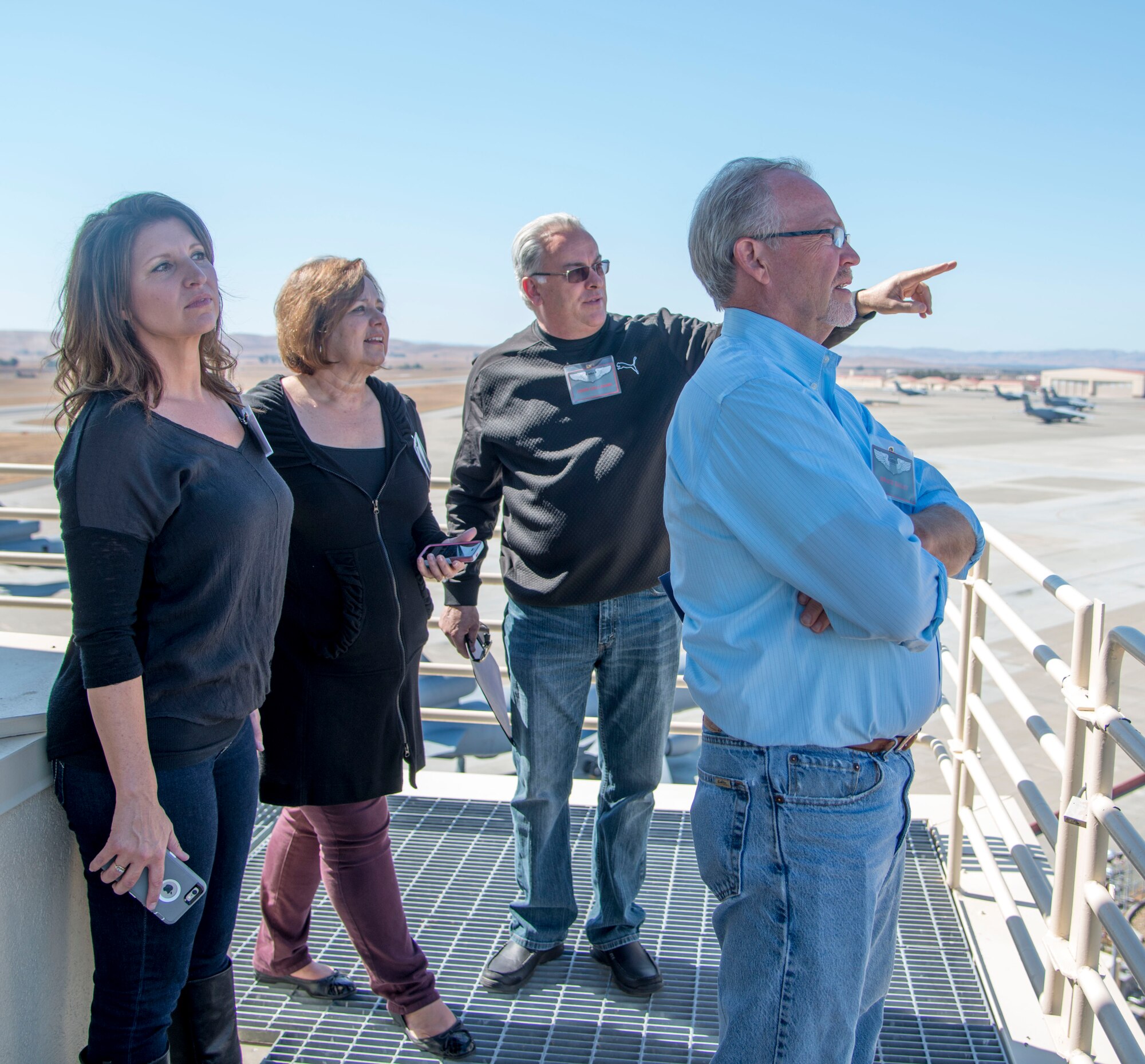 Honorary Commanders look out at Travis Air Force Base during the 60th Operations Group tour Oct. 2, 2015, where they prepped for a simulated mission to Souda Airfield, Greece. The Honorary Commanders received a mission, weather and intelligence briefing; were fitted with helmets and masks by aircrew flight equipment; toured the air traffic control tower and radar approach control facilities and received training on how to survive, evade, resist and escape capture before trying their skills in the flight simulators. (U.S. Air Force photo/Senior Airman Nicole Leidholm)