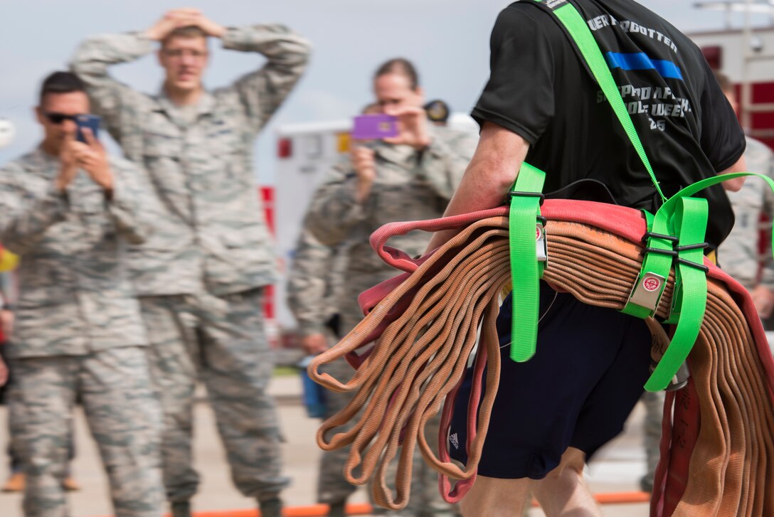An Airman from the 82nd Security Forces Squadron, carries fire hoses to his teammates during the 6th Annual Firefighter Olympic Challenge at Sheppard Air Force Base, Texas, Oct. 9, 2015. The challenge took place during fire prevention week as a means to raise awareness for fire safety and prevention. (U.S. Air Force photo/Senior Airman Kyle Gese)