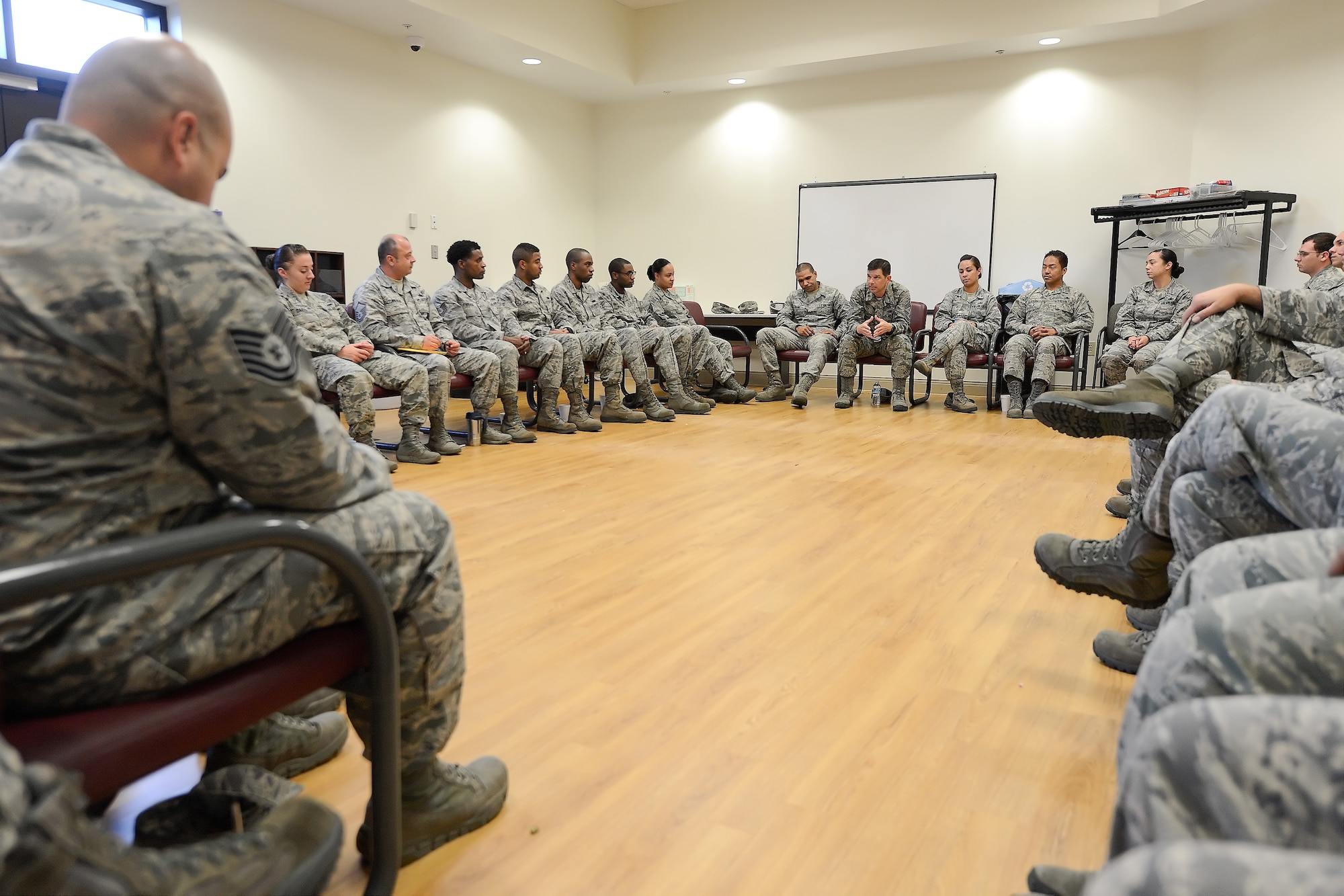 Team Dover enlisted personnel of various ranks listen to Chief Master Sgt. Keith Davis, 436th Airlift Wing command chief, center, as he tells his story during a professional development session titled, "Every Airman has a Story," Oct. 8, 2015, at Dover Air Force Base, Del. Davis engaged the audience with personal details of a challenging childhood and how he was inspired to succeed in life and reach the pinnacle of enlisted ranks within the Air Force.  (U.S. Air Force photo/Greg L. Davis)